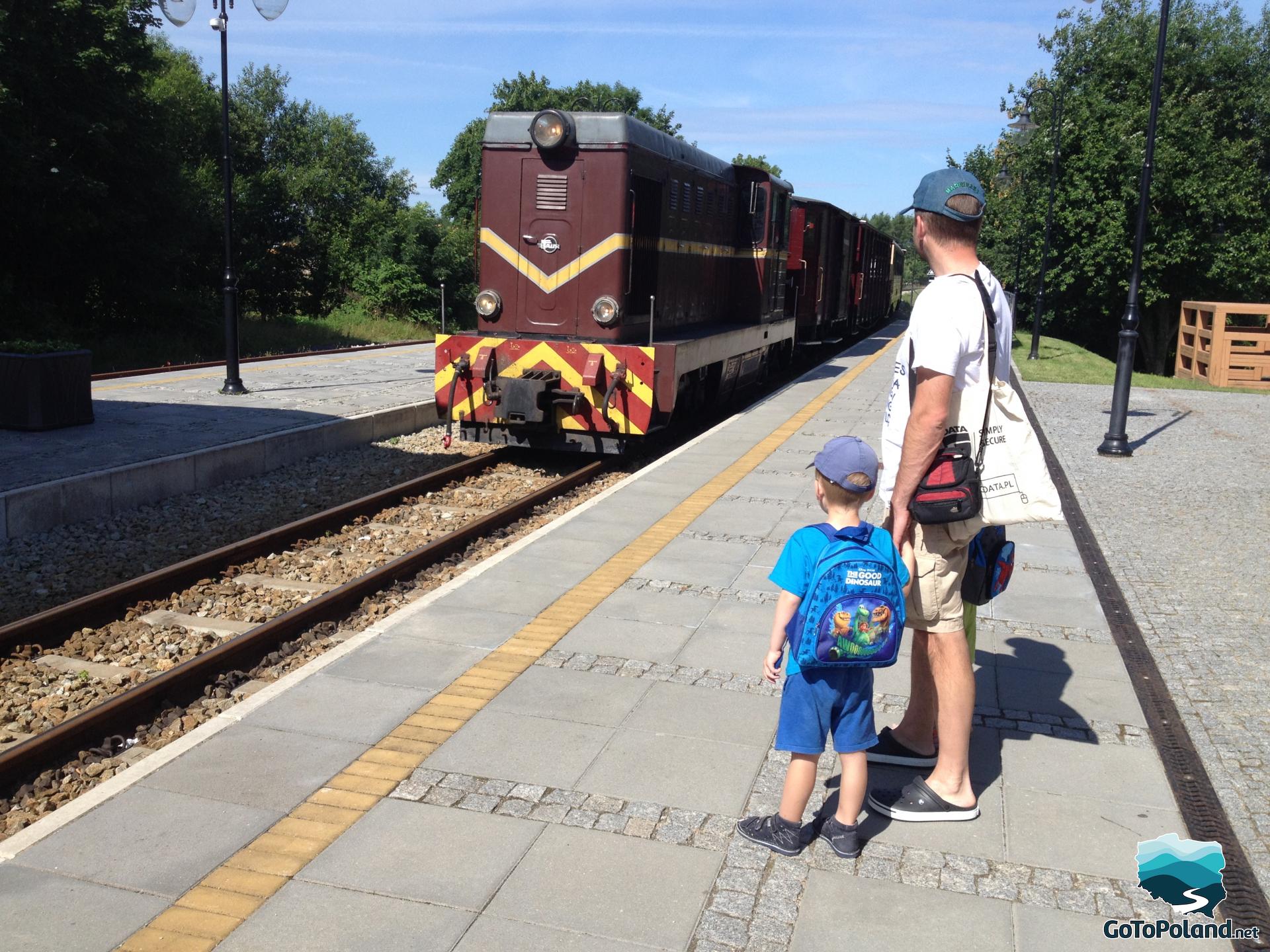 two boys and a man at the train station