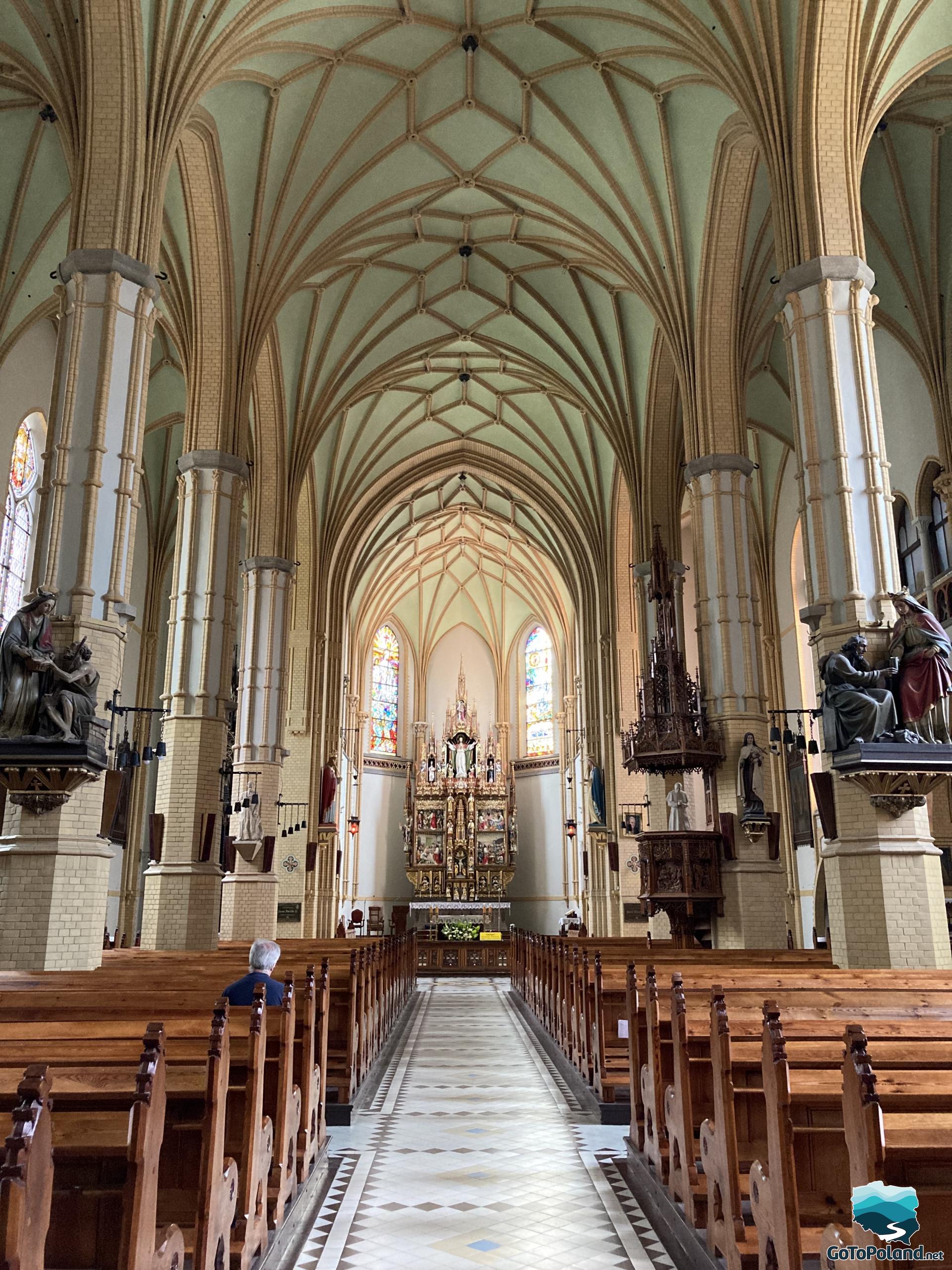 the interior of the church with rows of pews and the main altar in the background