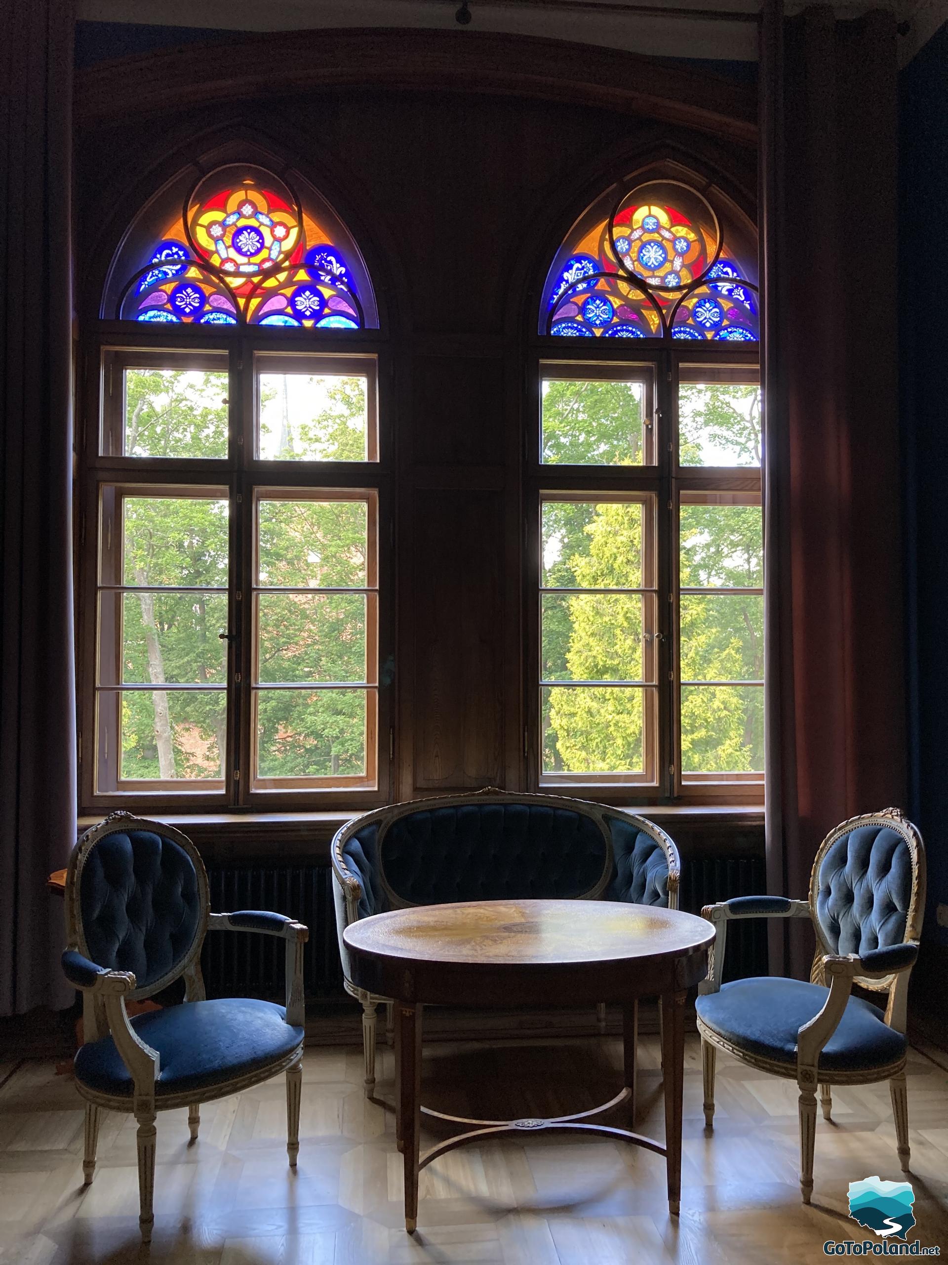 stained glass windows and an ornate wooden table with chairs