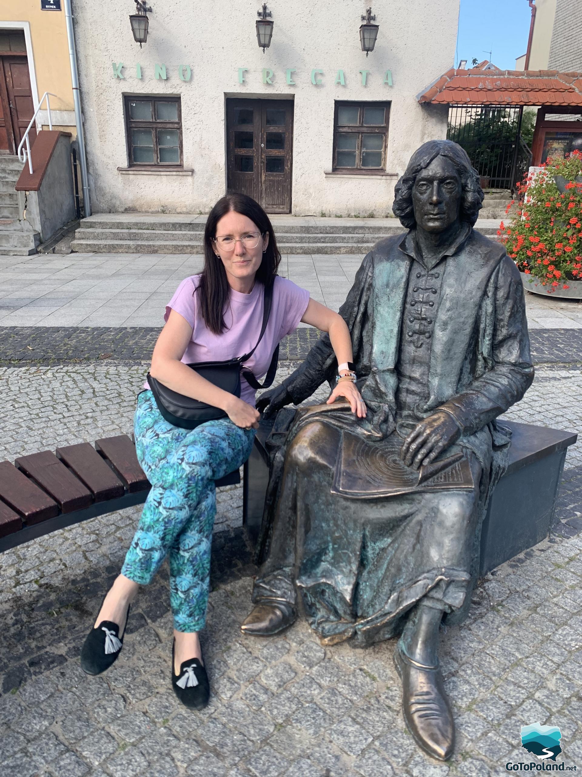 a woman sitting next to the Copernicus monument
