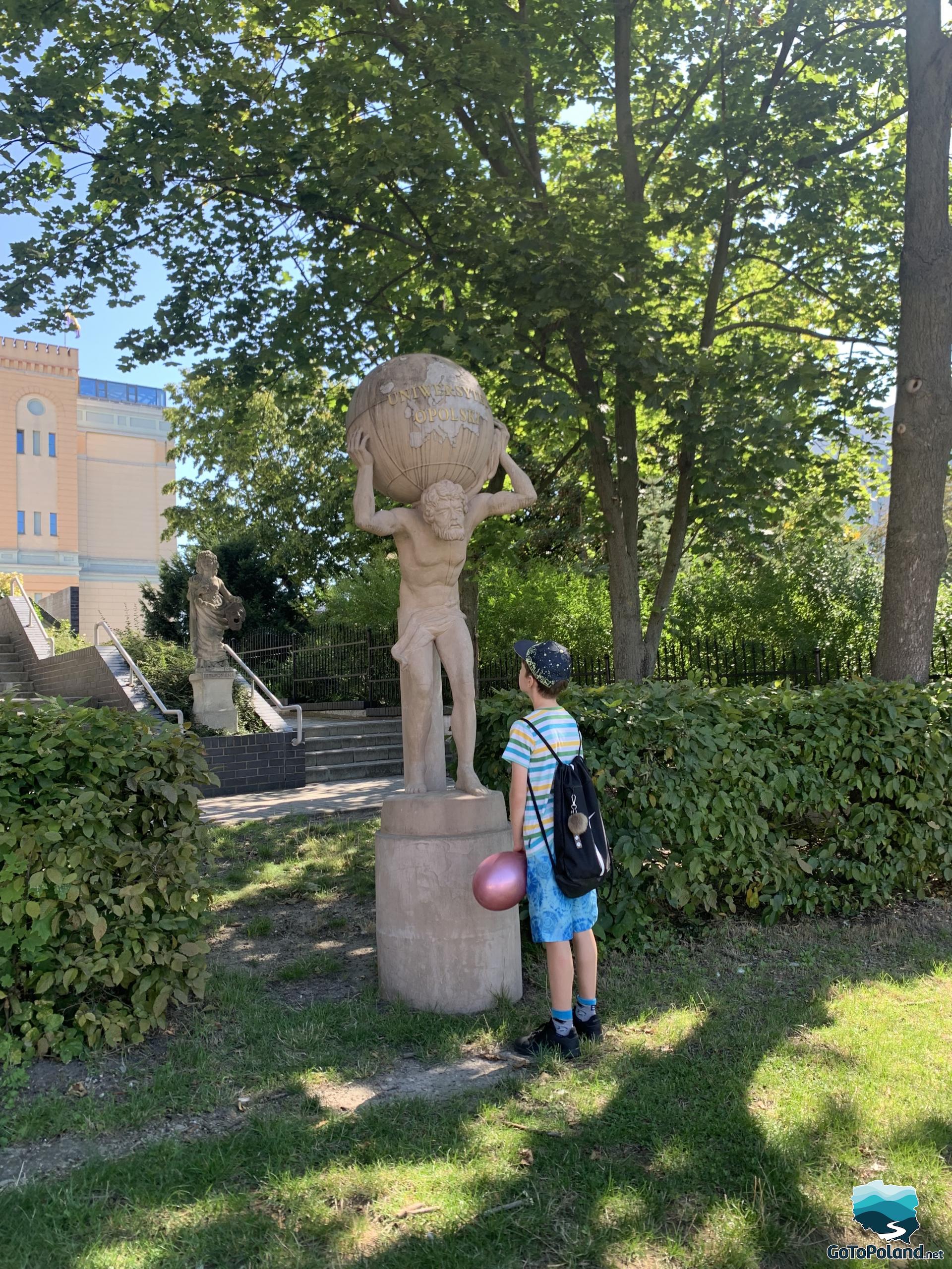 the boy looking at the atlas, which has the inscription University of Opole