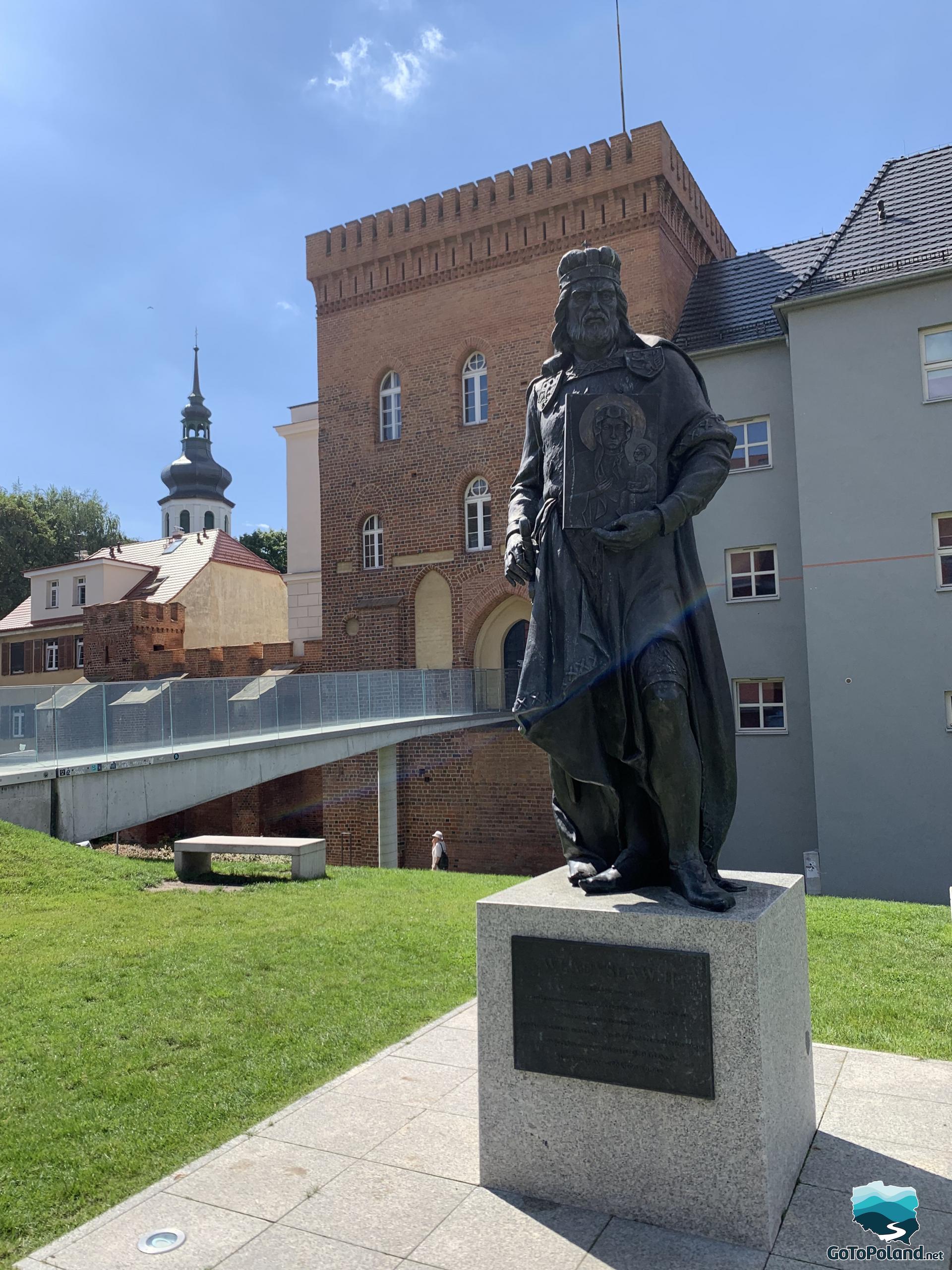 a sculpture of polish Prince Władysław II in the foreground, in the background a castle 