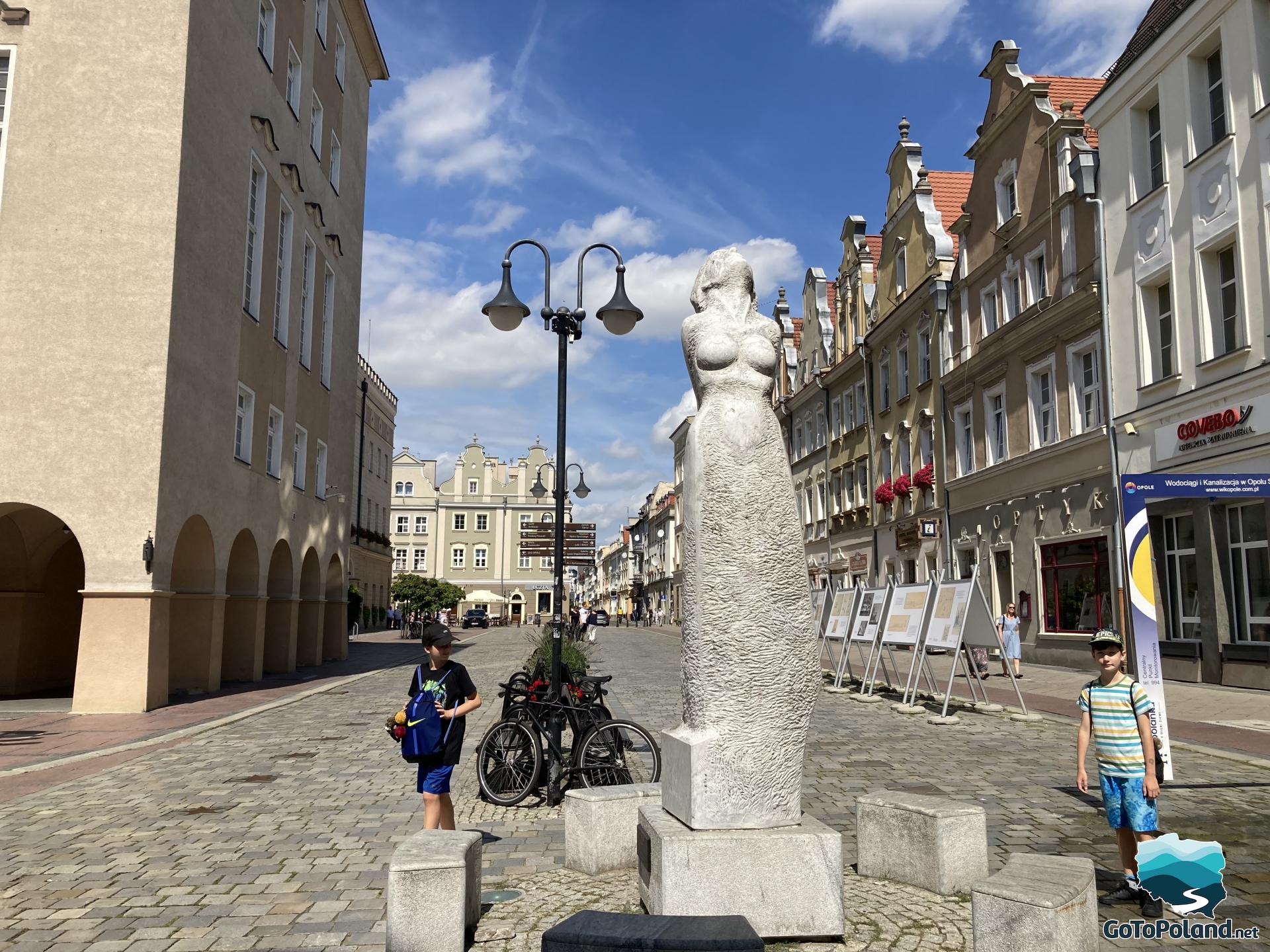 a stone sculpture of a naked woman on the main market
