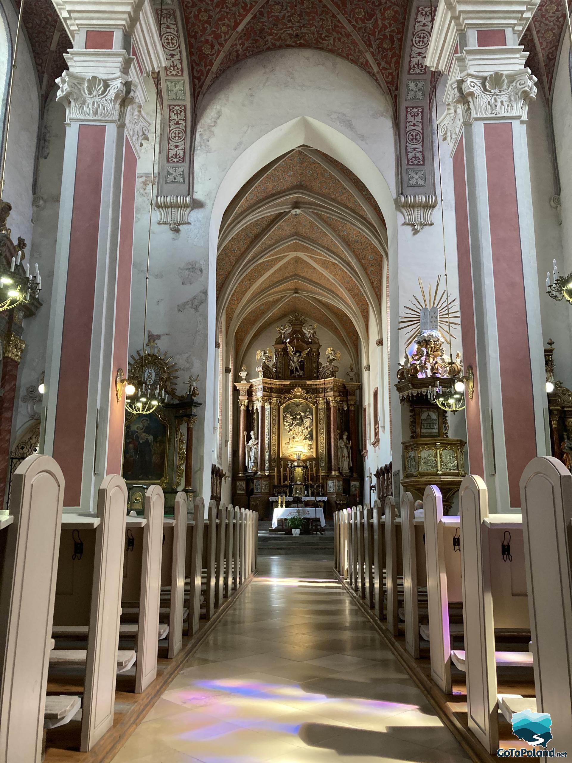 view of the interior of the church with the main altar, side altars and pews