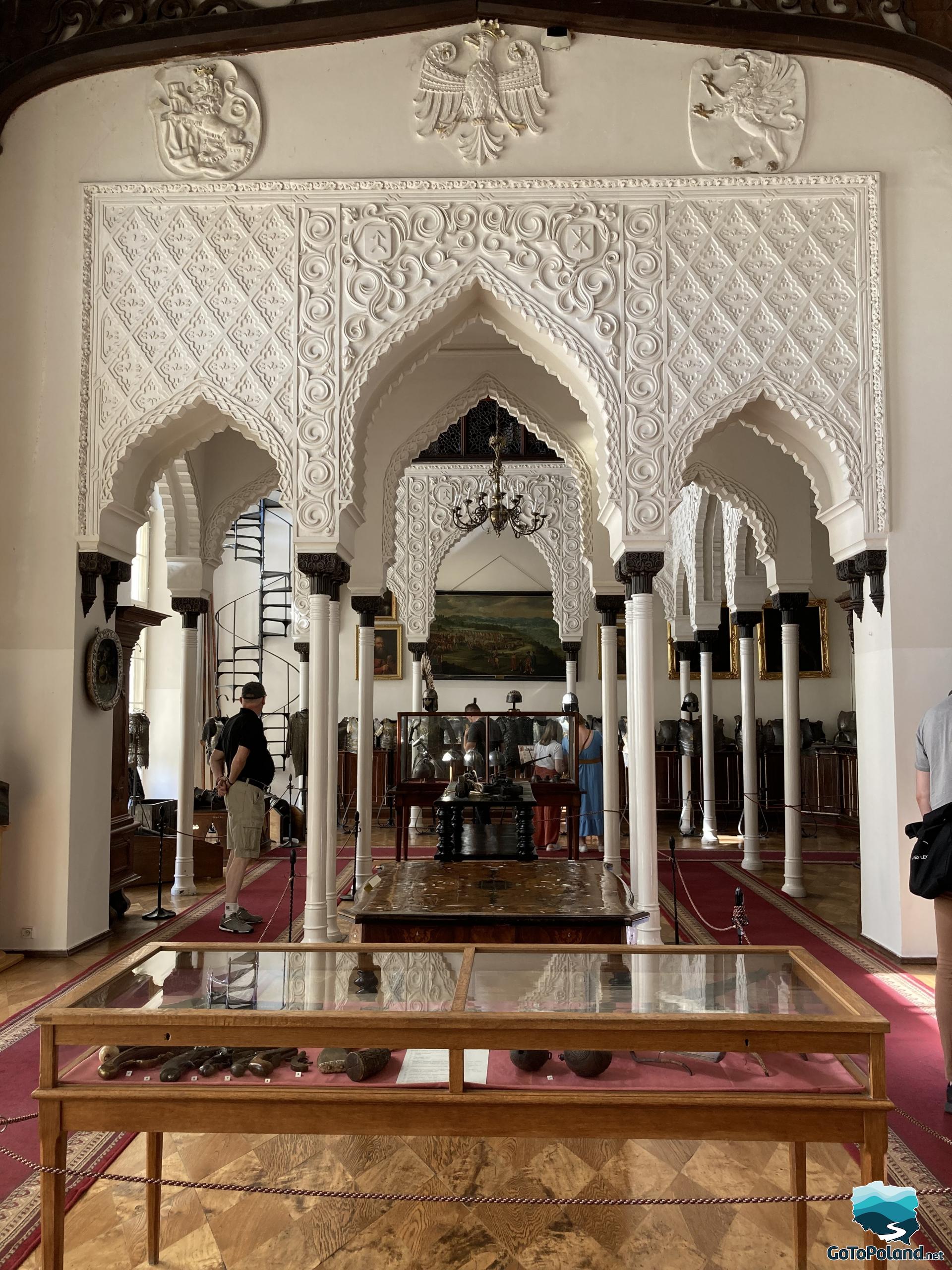 a room in the Moorish style, shelves with porcelain, few tourists viewing the exhibitions