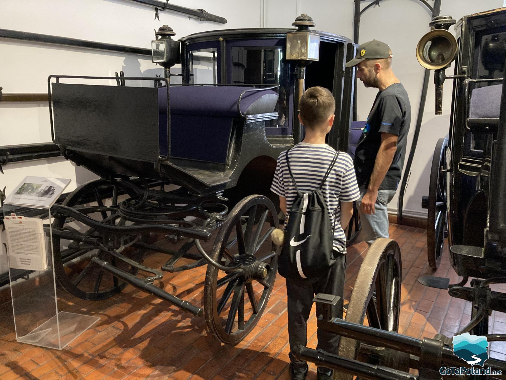 a boy and a man are looking inside a carriage