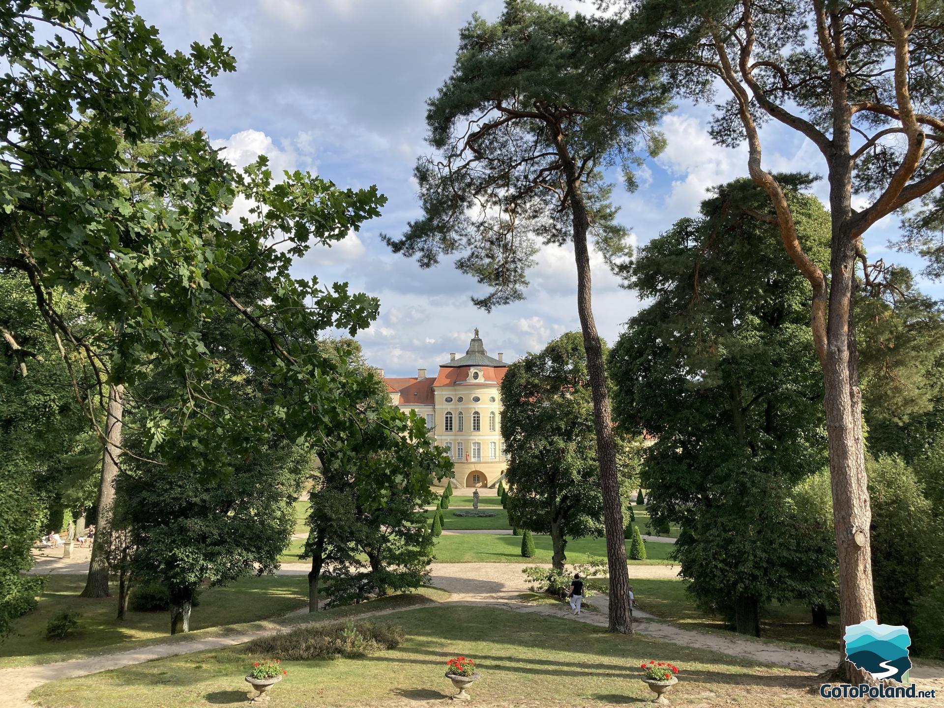 The palace emerges from among the trees