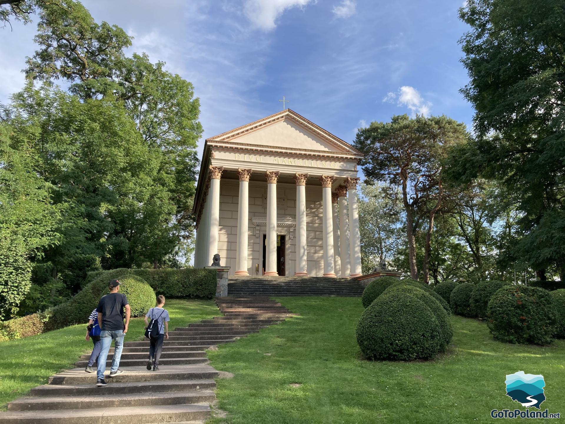 a man and two boys are going to a building reminding a greek temple with columns in corinthian style