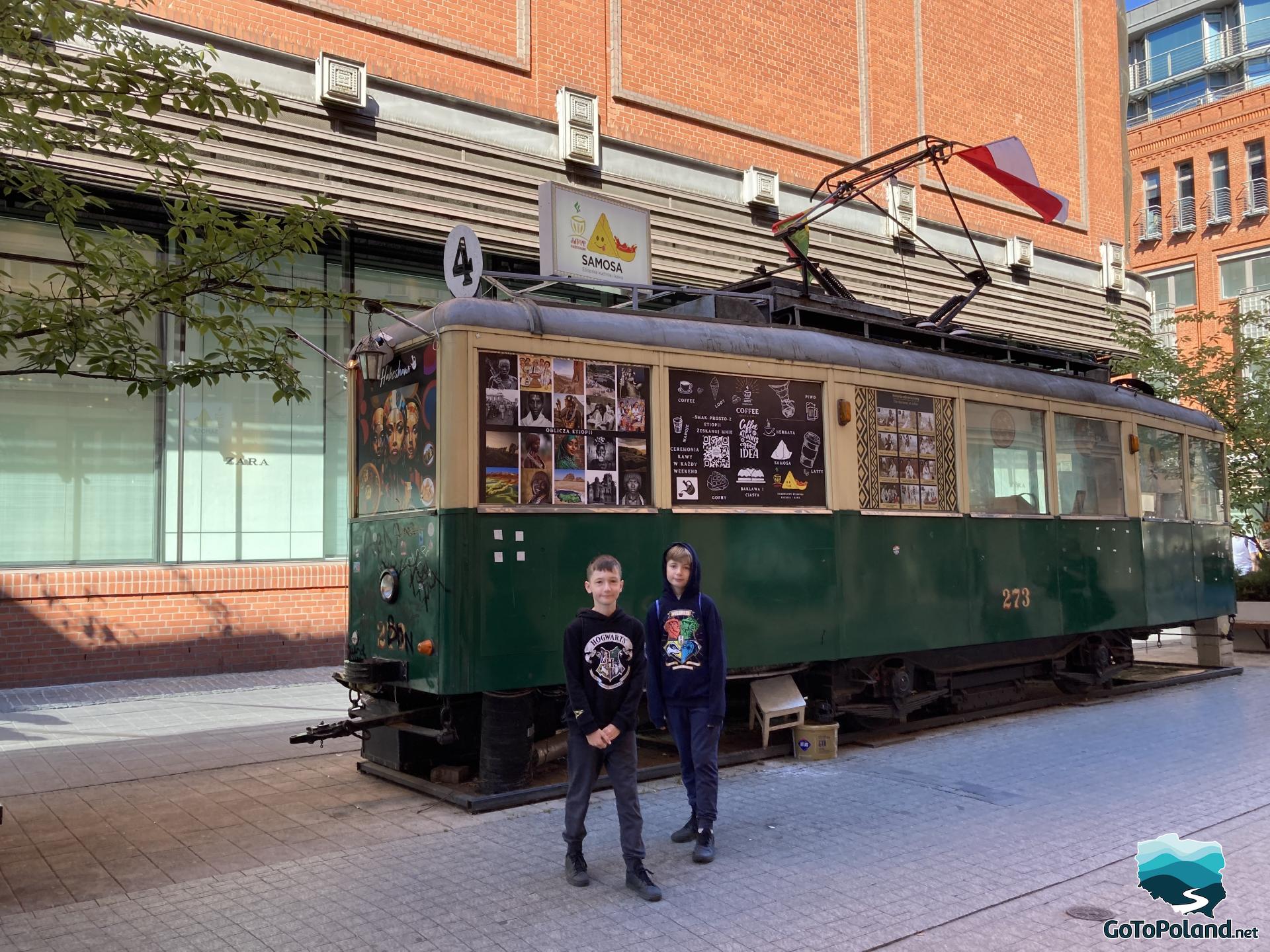 children stand next to the former tram