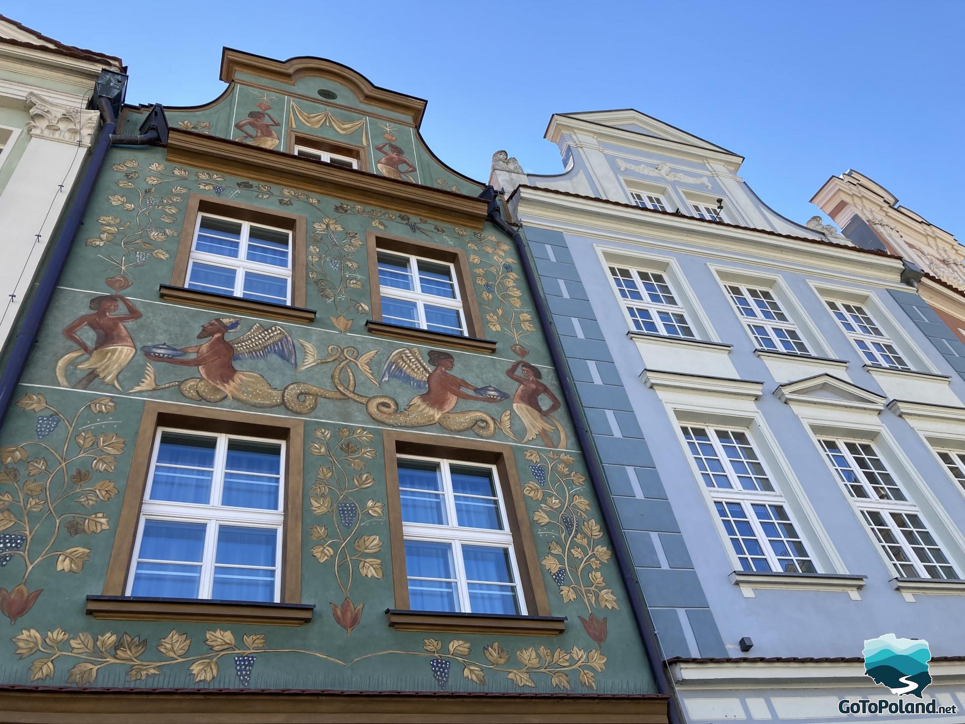 richly decorated facade of the tenement house with drawings of certain figures, leaves and grapes