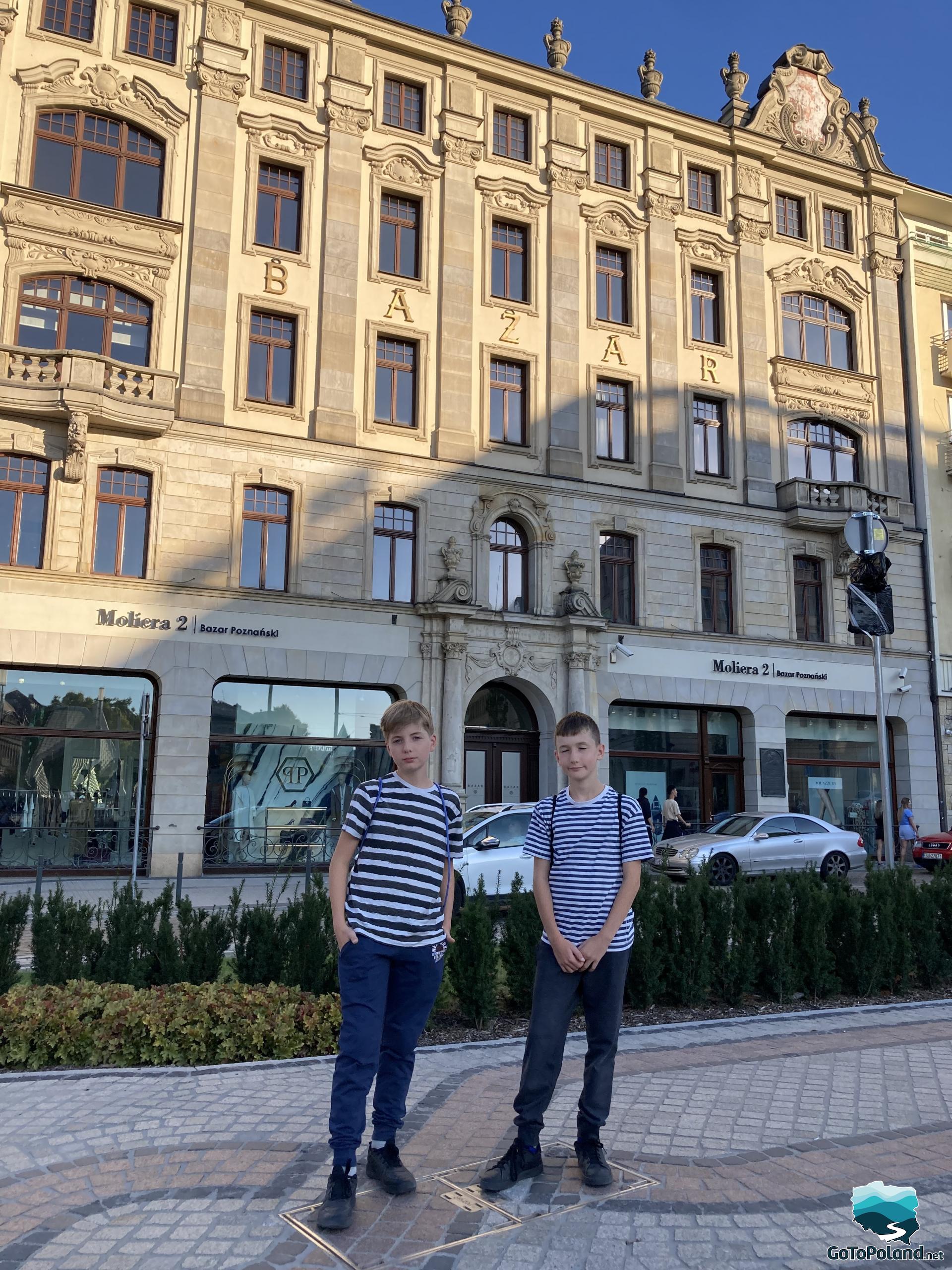 two boys standing in front of an old building where the hotel is located