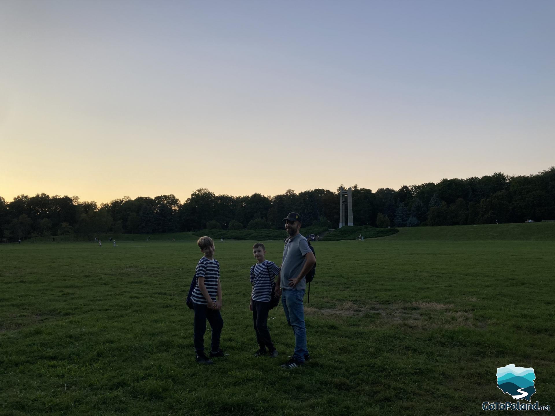 a man and two boys are in the middle of a meadow 
