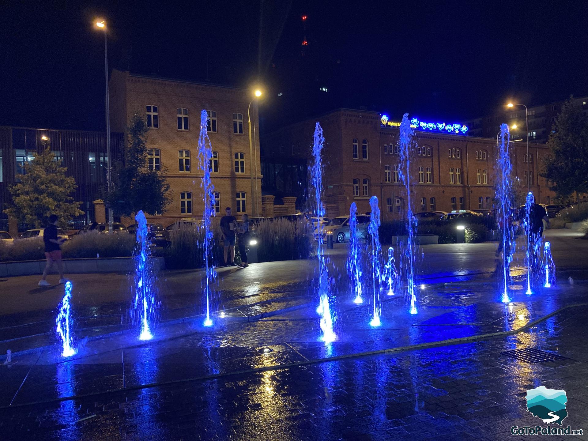 blue-lit fountain seen at night