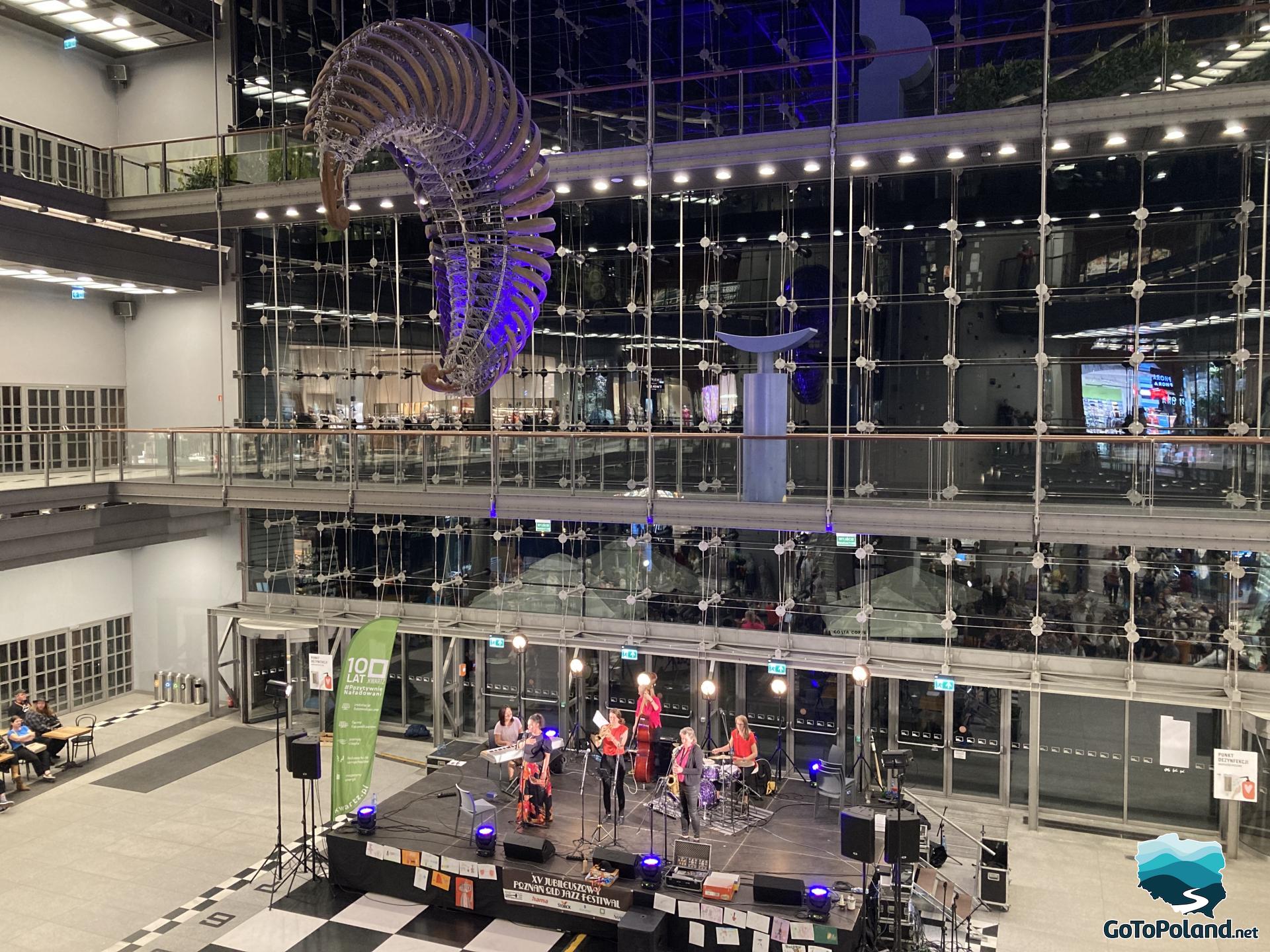 a small stage with singers and musicians located in a shopping mall