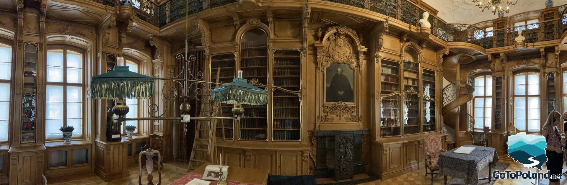 wooden library, wooden shelves, lots of books, wooden stairs leading to the upper floor