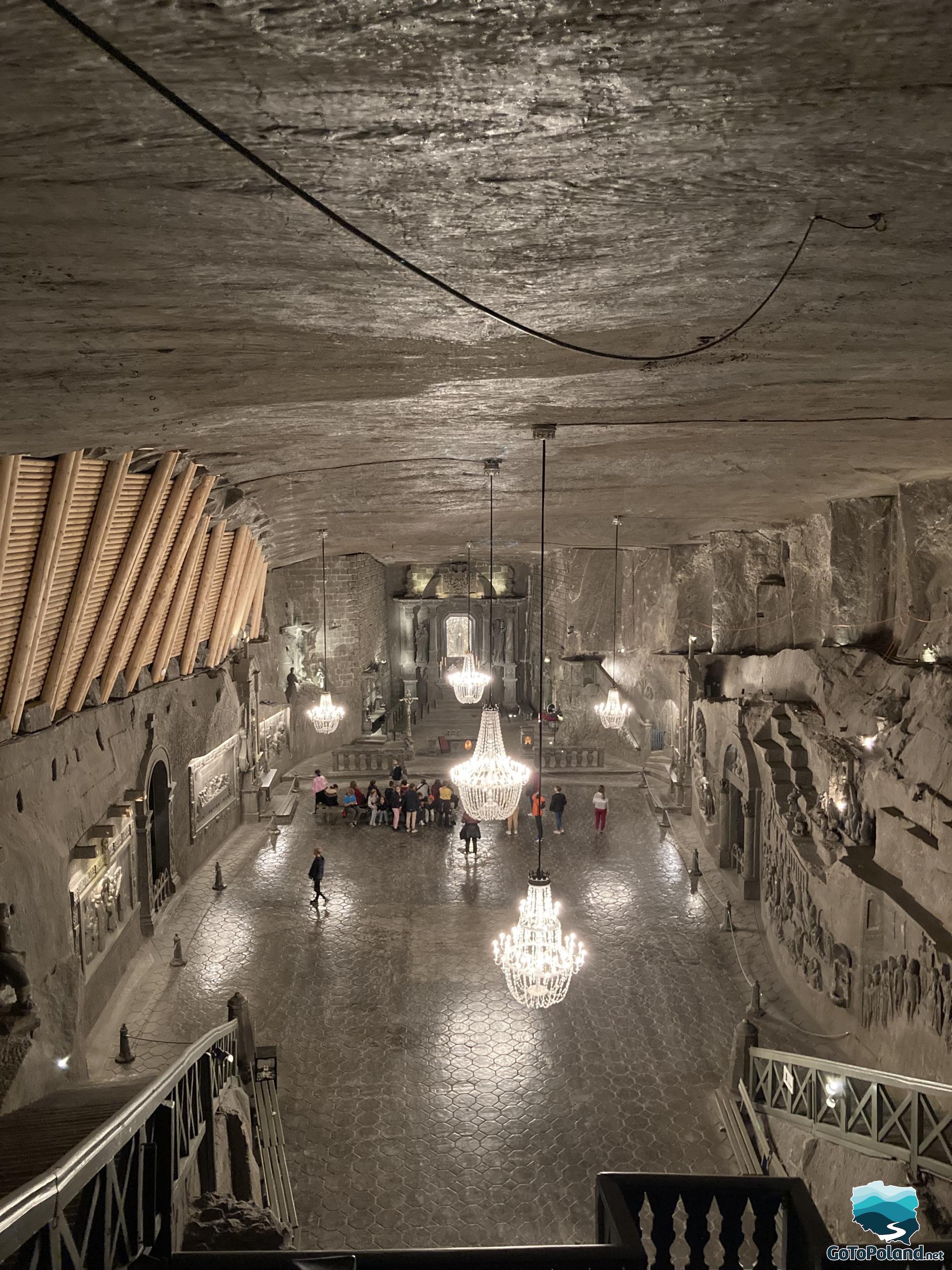 a huge chamber made of salt, a group of tourists, 5 salt chandeliers
