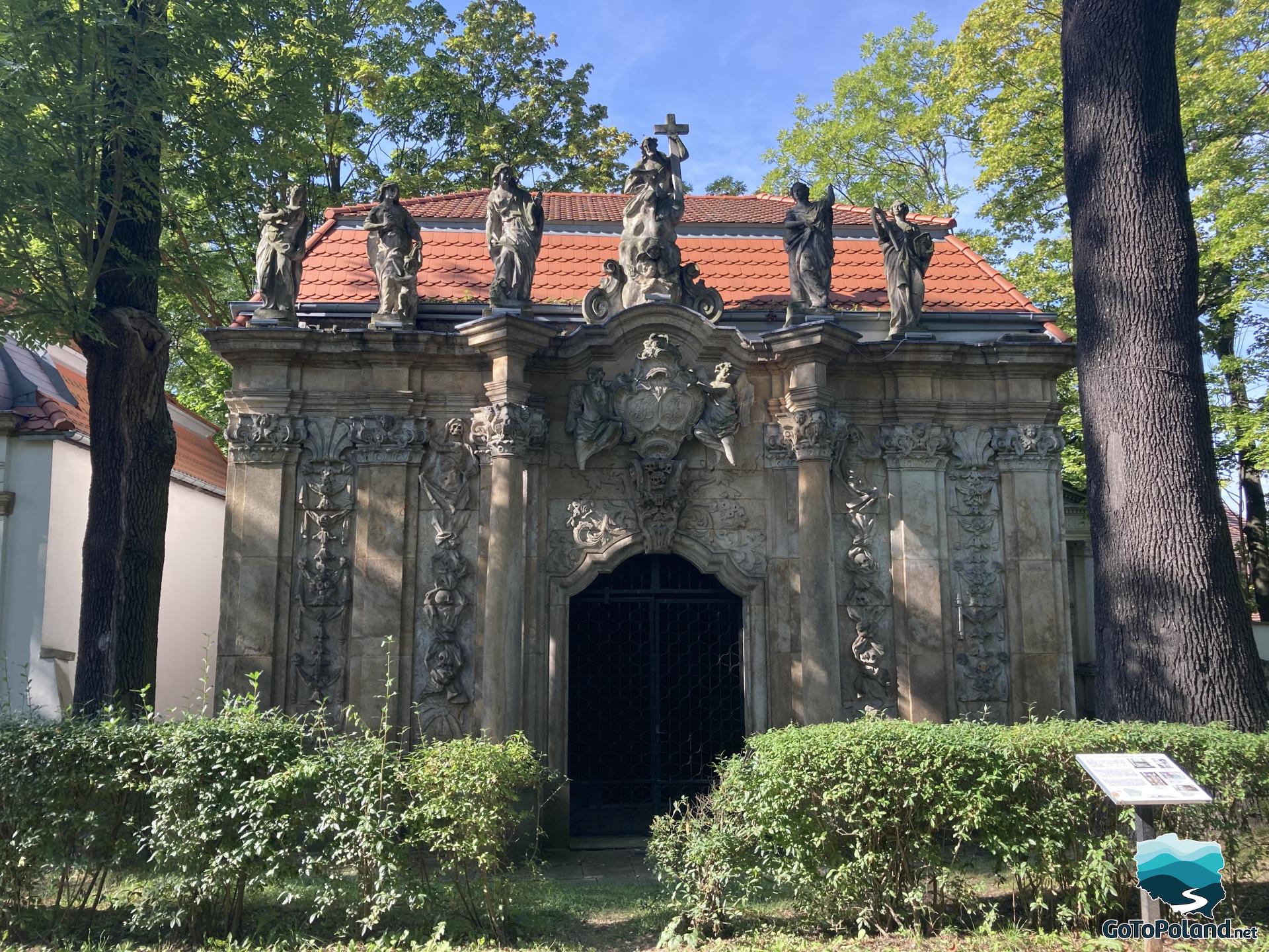 a small chapel with several stone sculptures on the roof