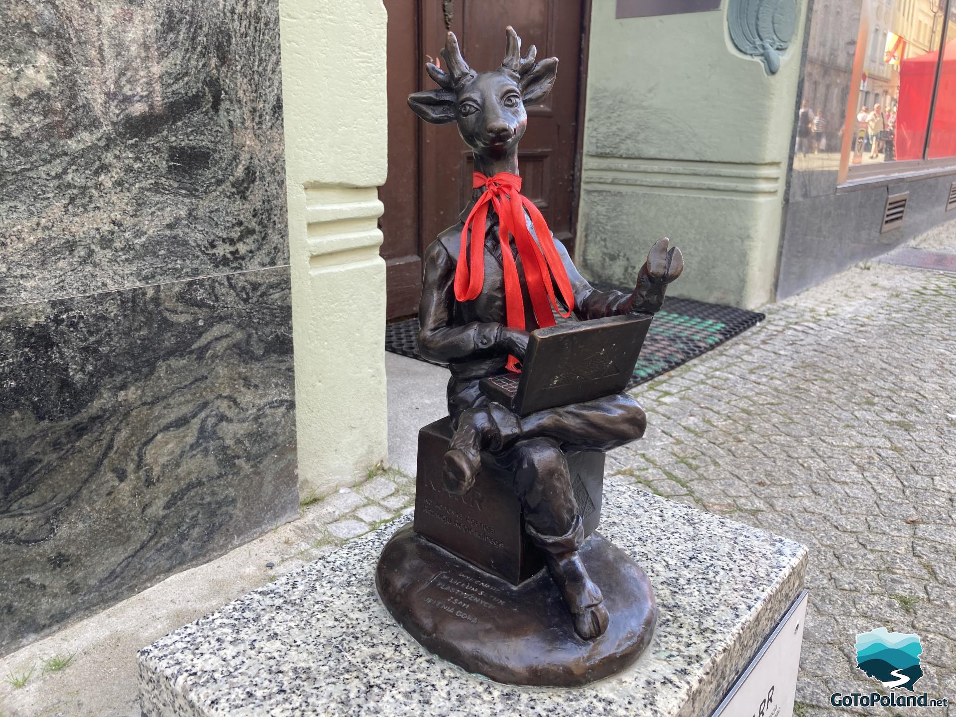 a small statue of deer with a notebook