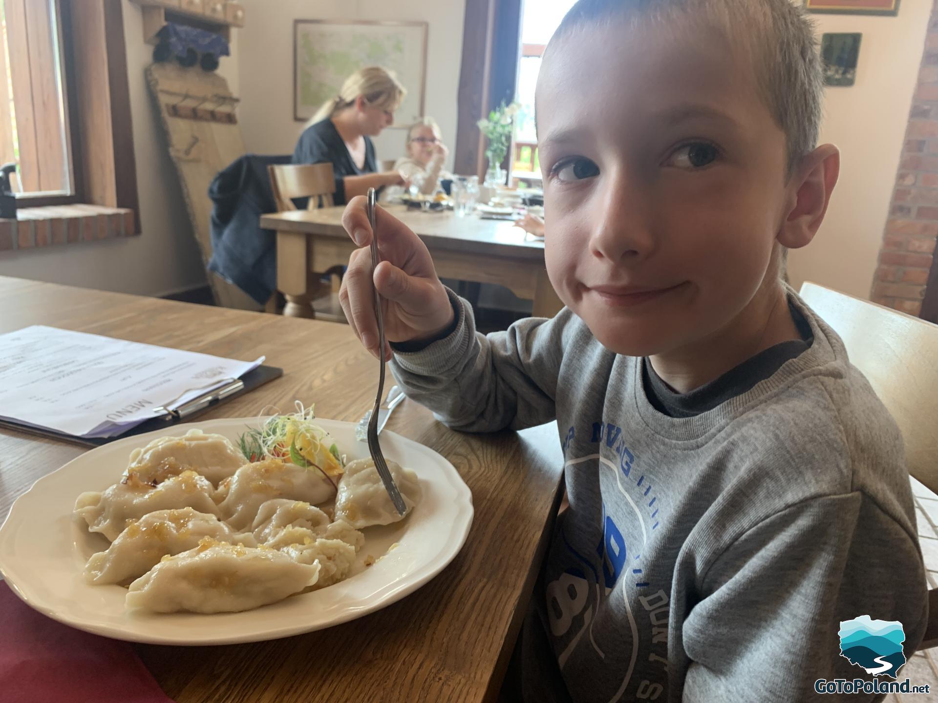 a boy is eating dumplings