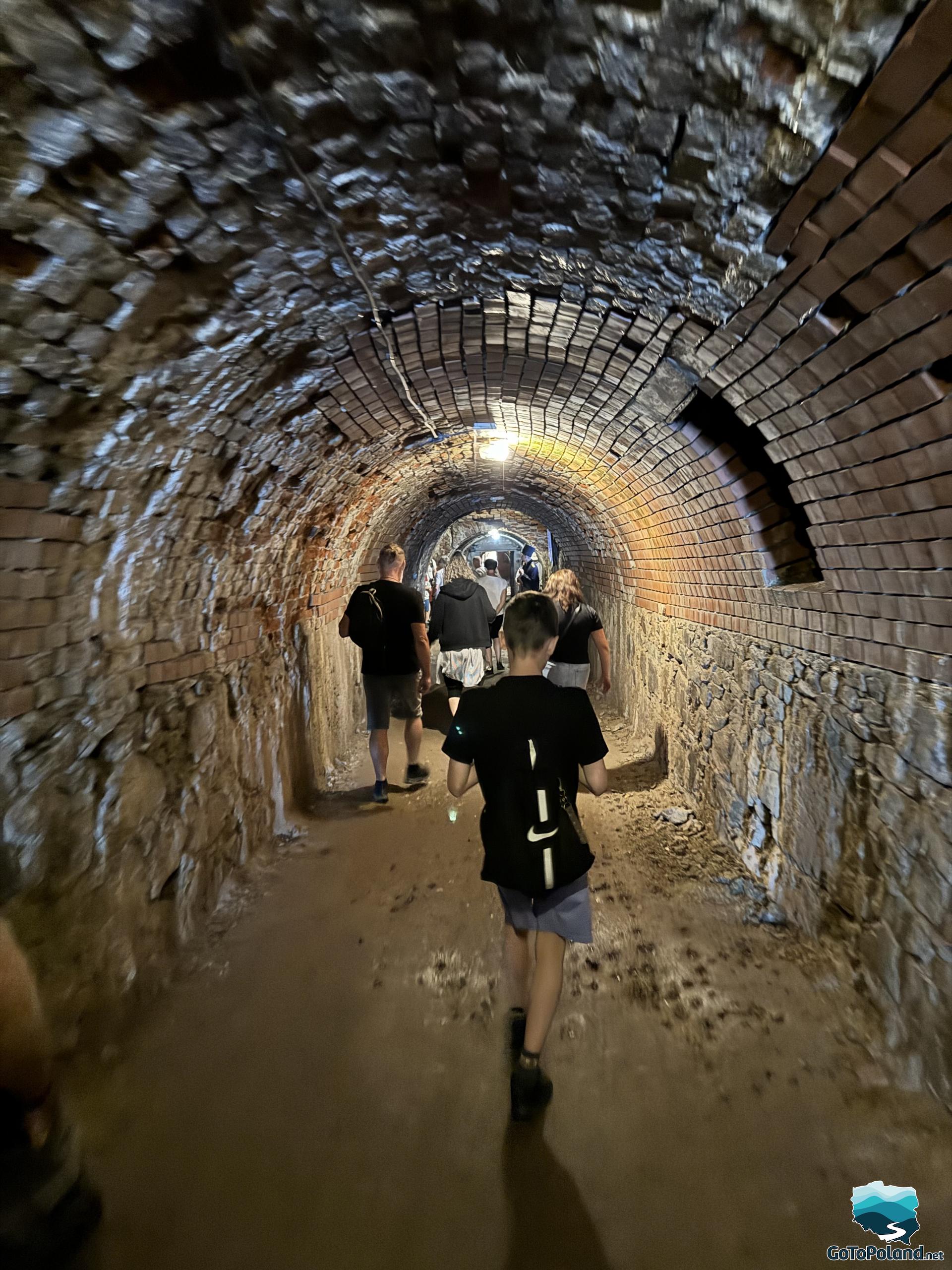 a boy walks through dark tunnels