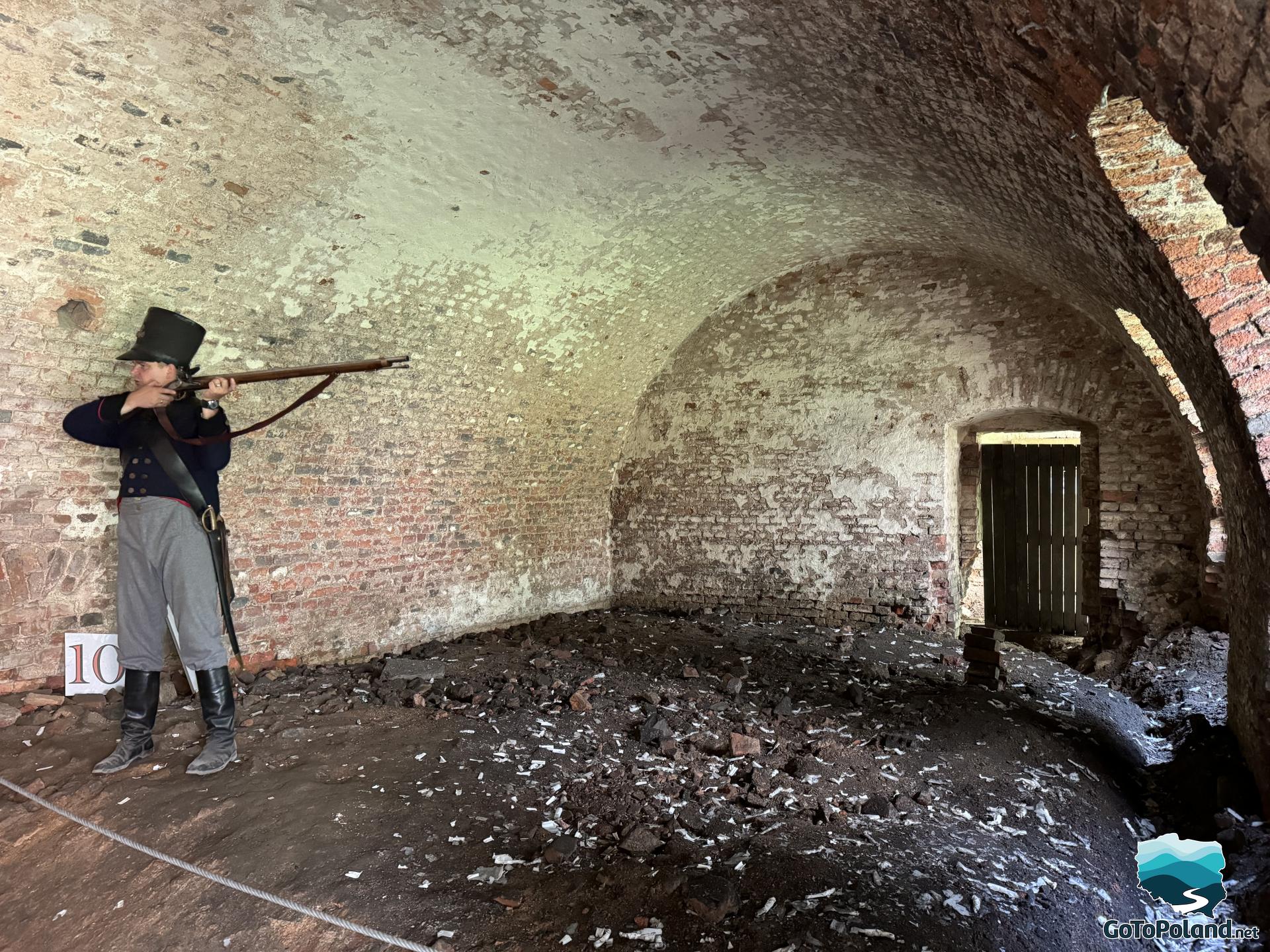 A guide dressed as a Prussian soldier measures with a rifle