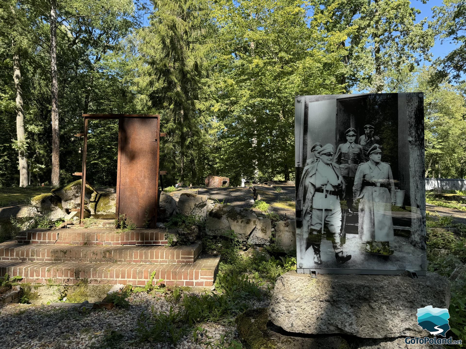 ruins of a barrack next to which there is a vertical photo of NSDAP officers