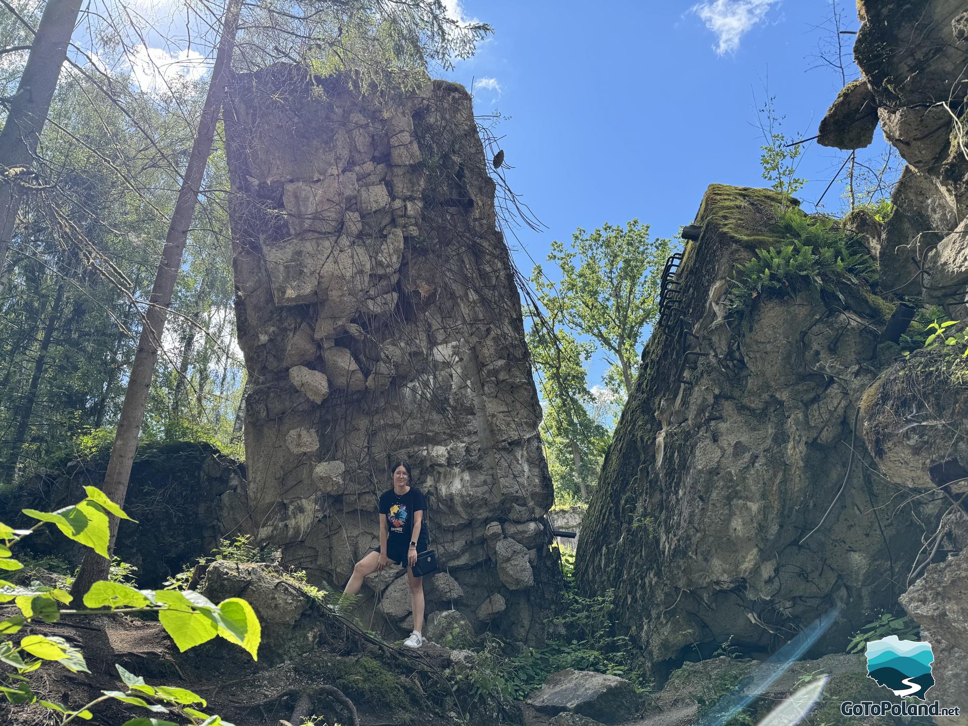 a woman standing on the ruins of a shelter