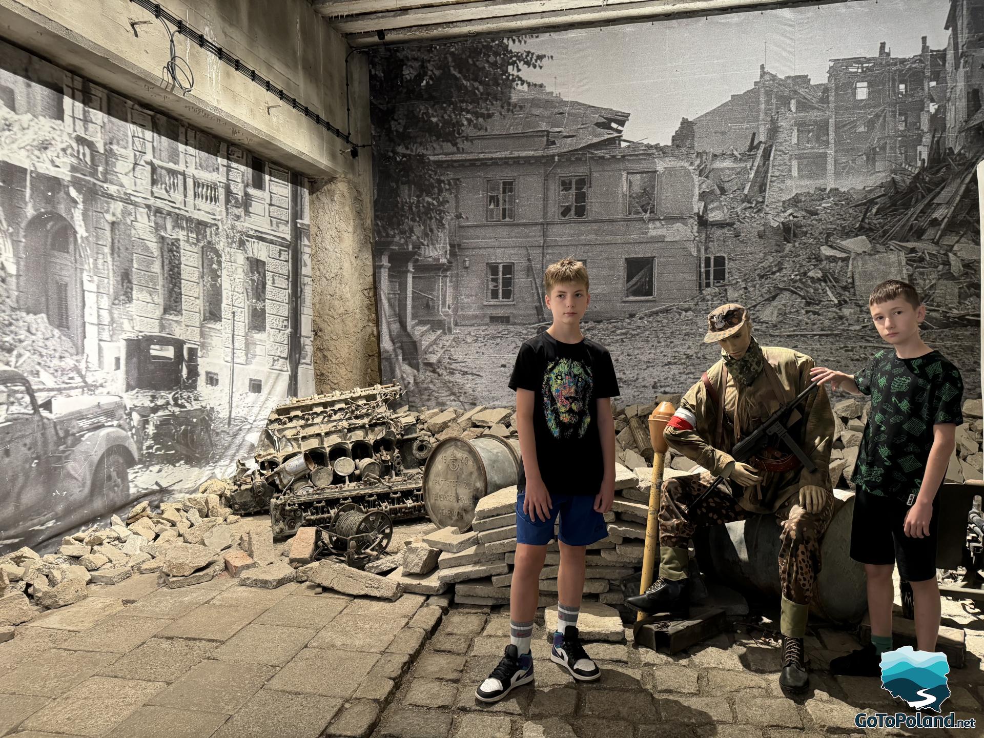 two boys standing next to the exhibition from the Warsaw Uprising