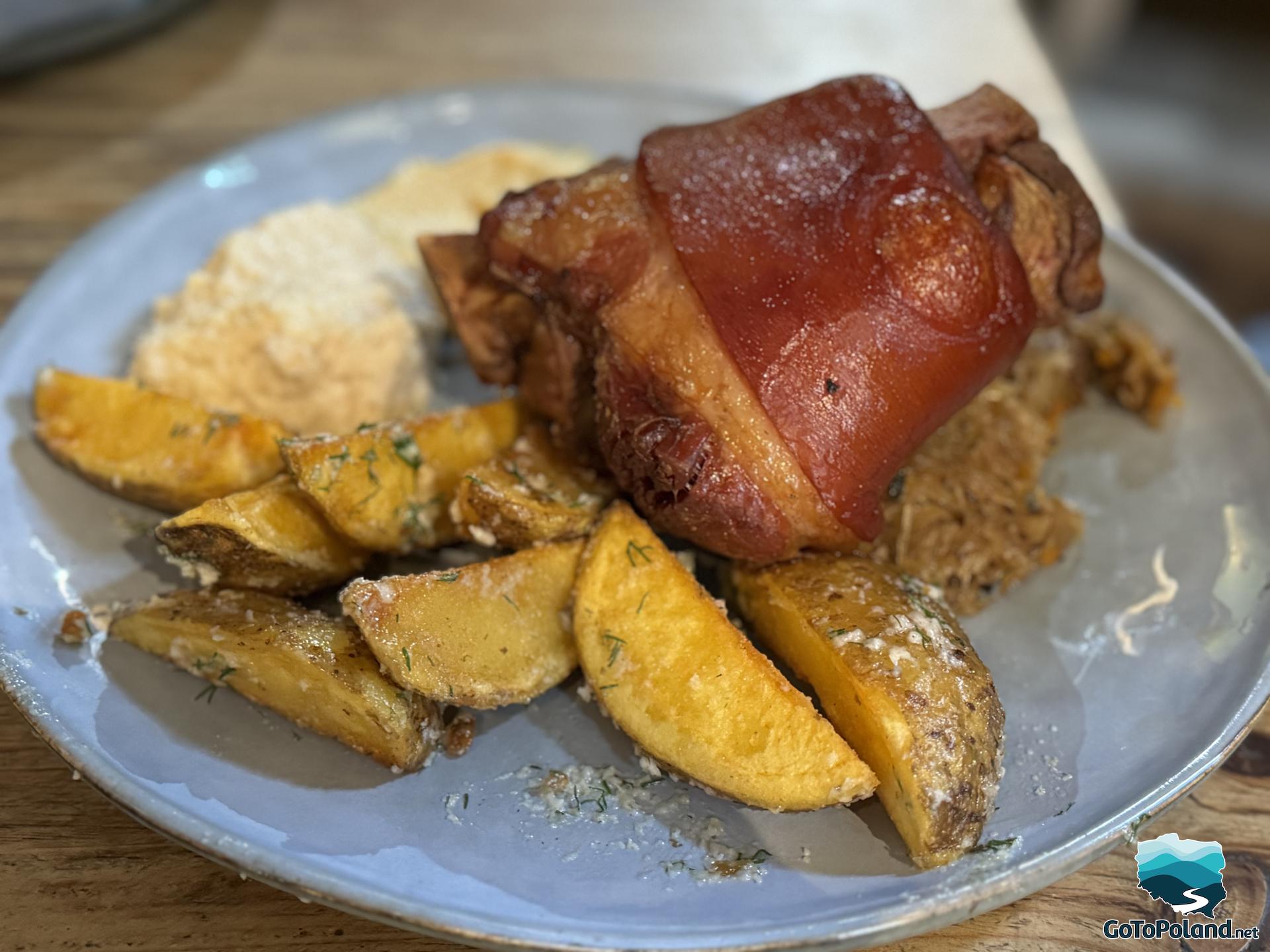 on a plate roasted pork knuckle with potatoes