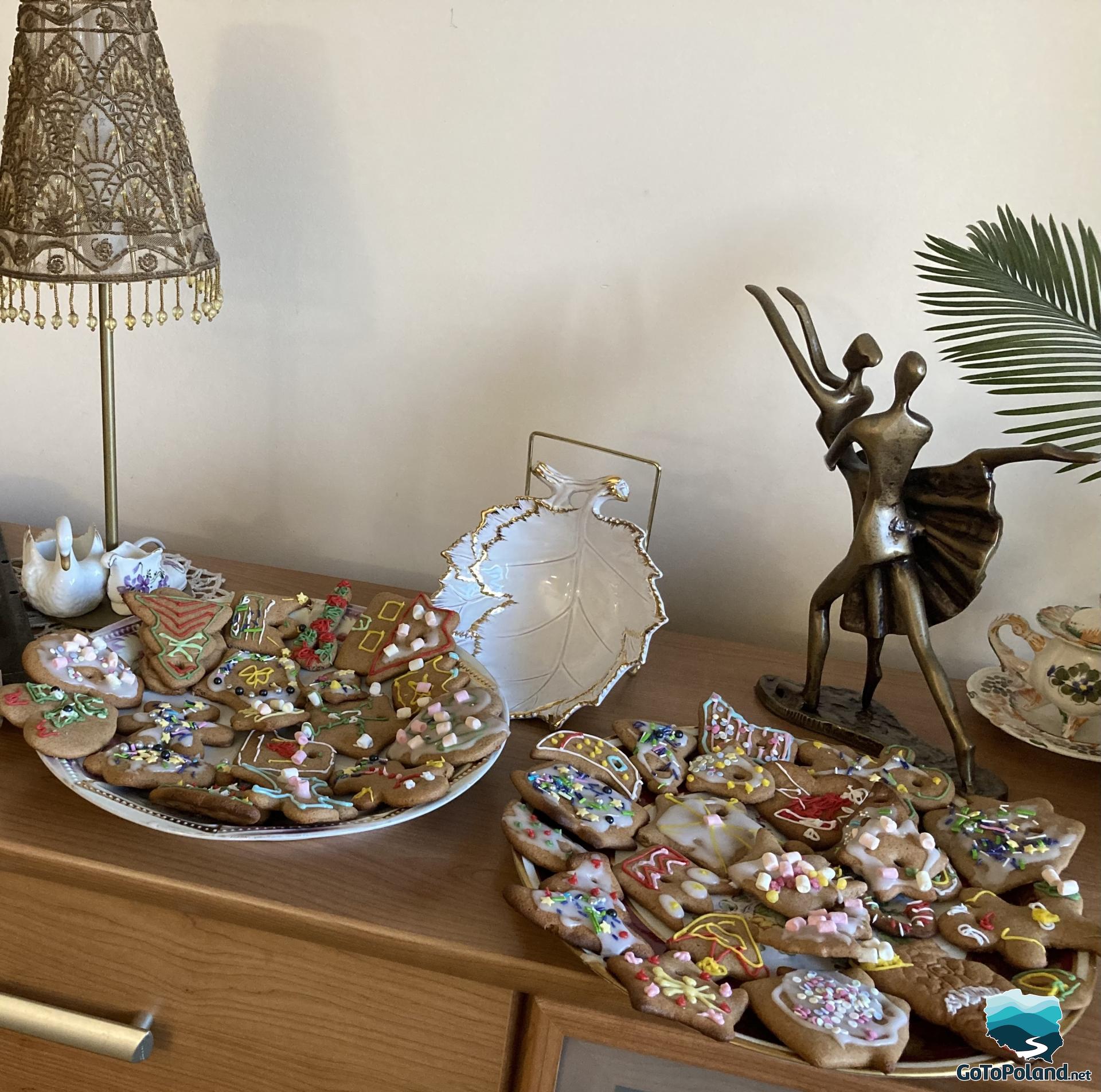 On two plates on the dresser lie decorated gingerbread cookies