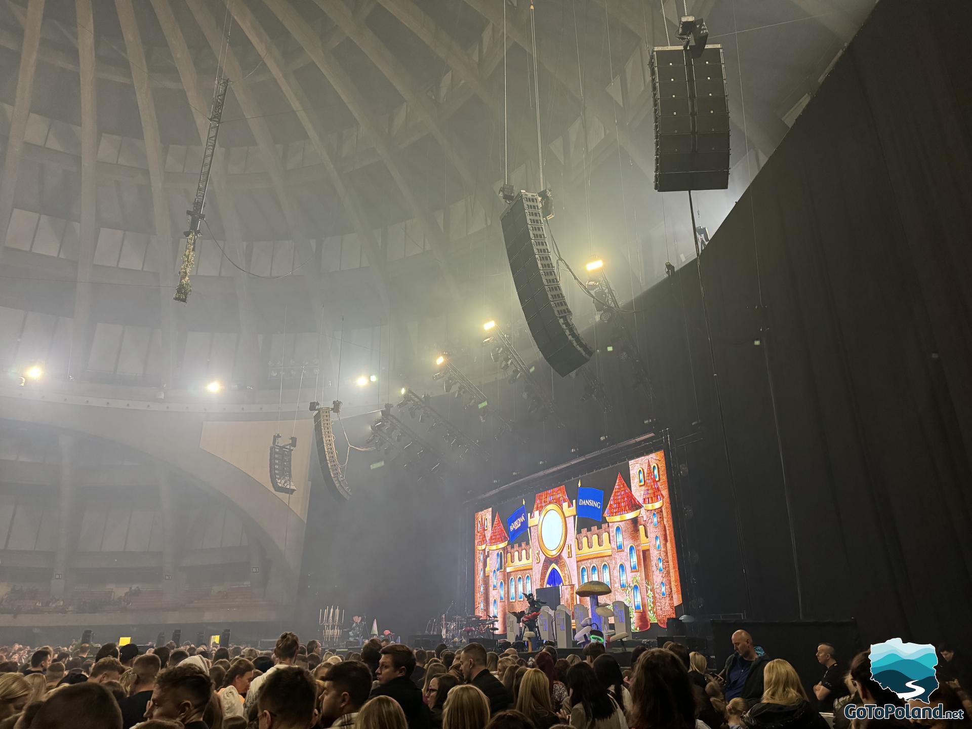 inside the hall, the crowd is waiting for the singer, the roof is dome-shaped