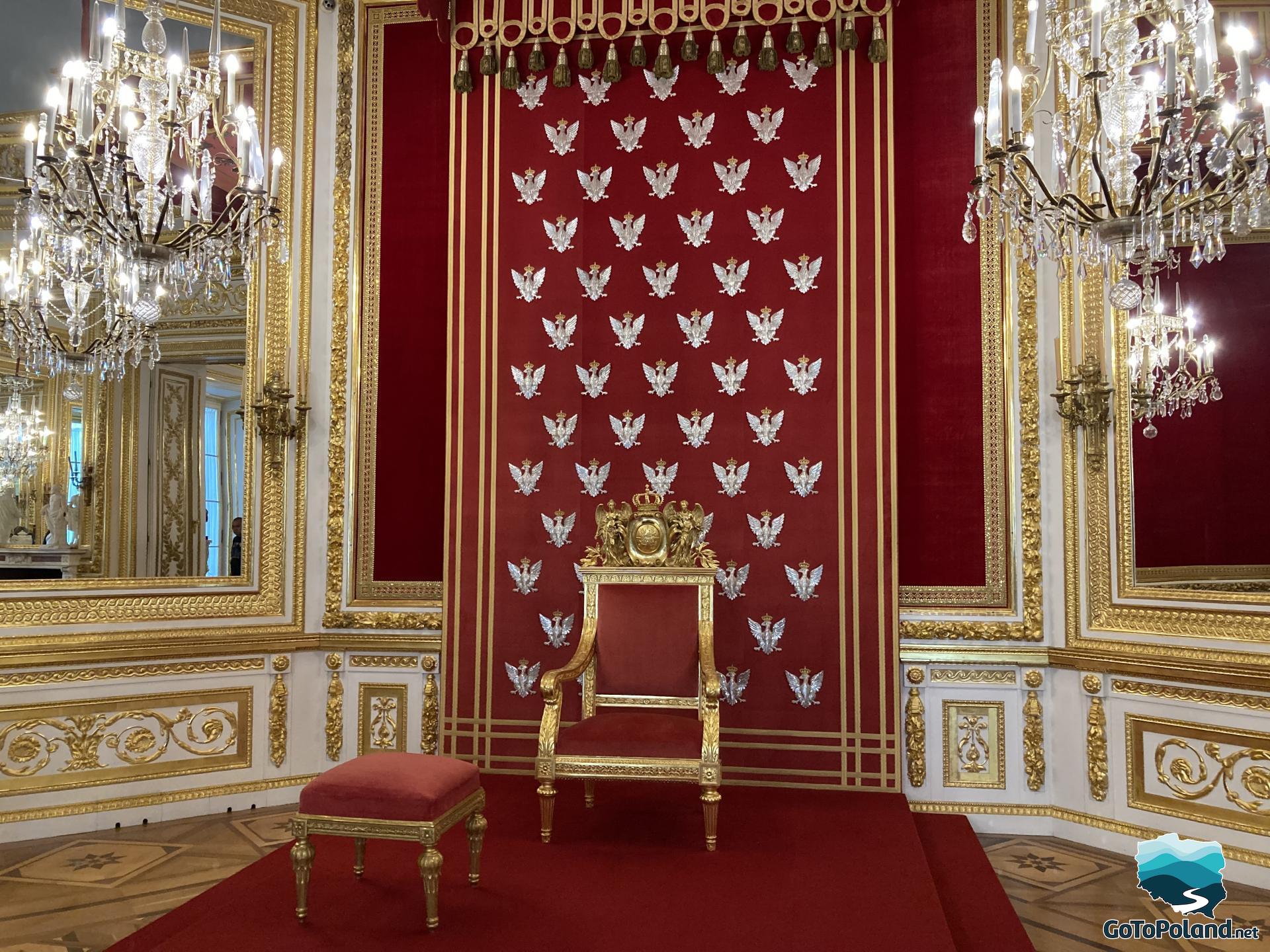 a red-gold throne close up, two huge mirrors in golden frames, behind the throne is a wall of red fabric on which small silver eagles are pinned