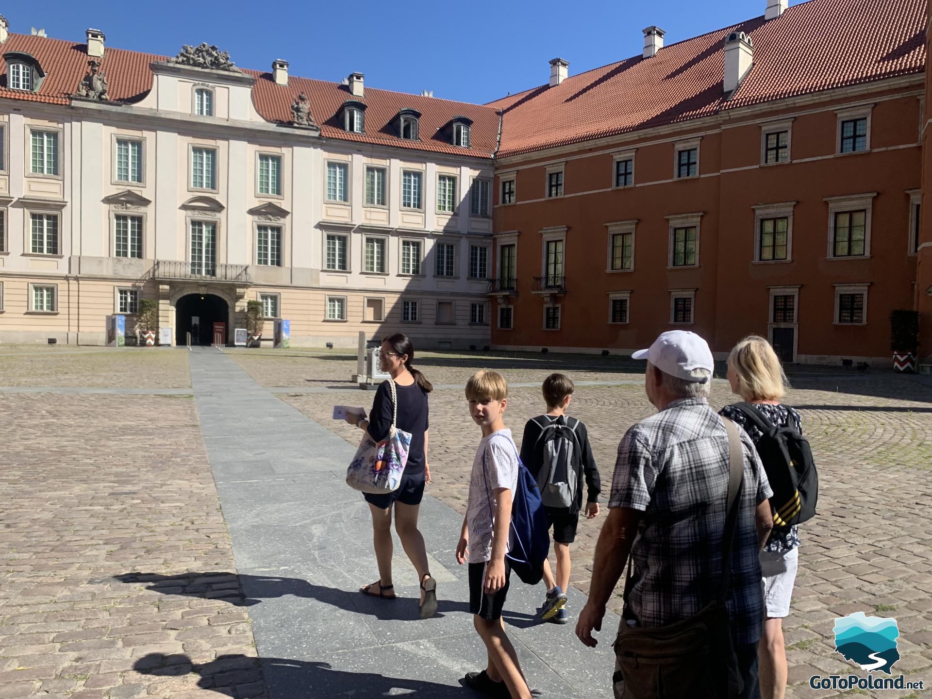 the family is walking along the courtyard of the castle
