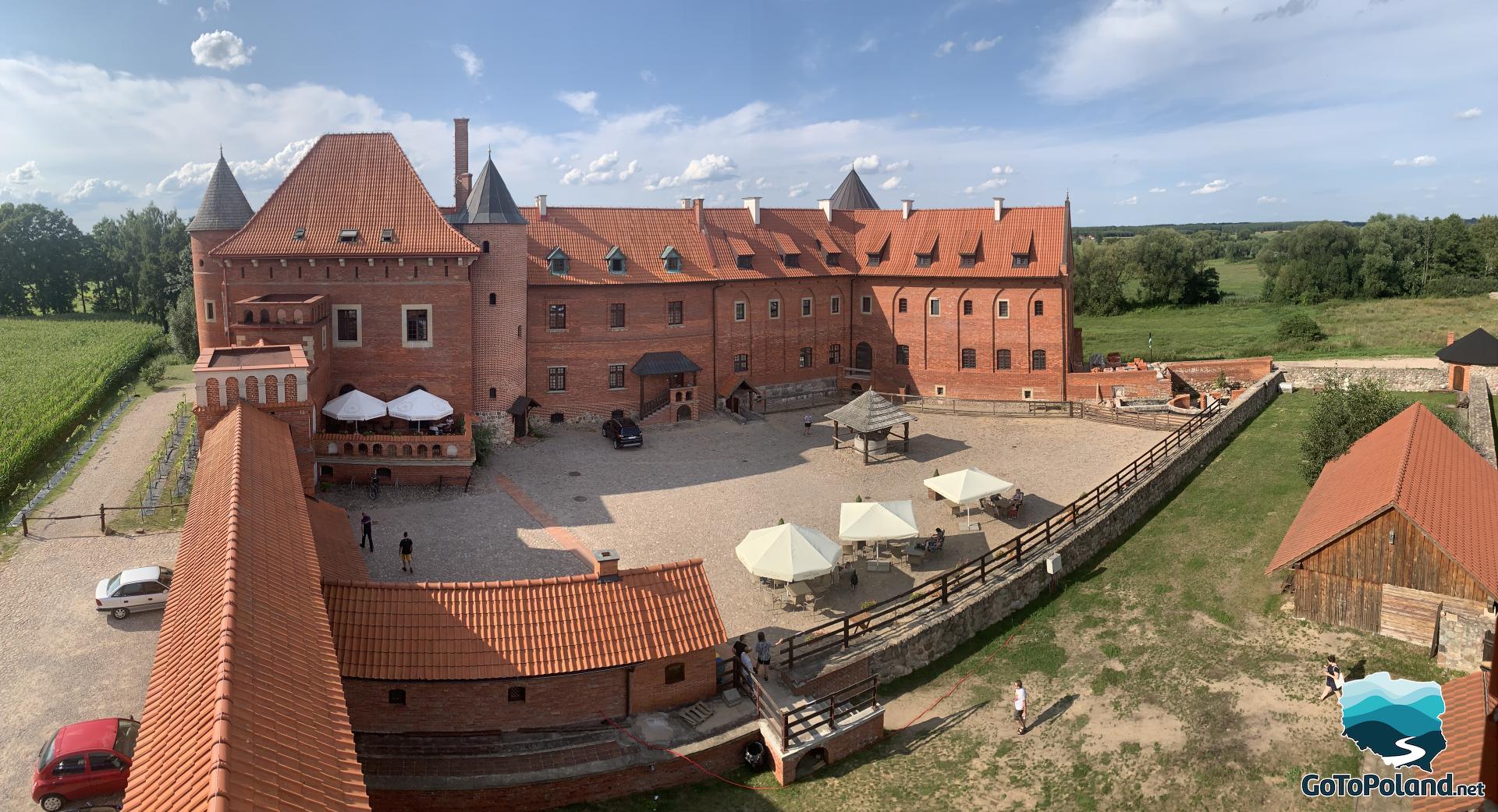 panoramic photo of a restored castle made of red bricks