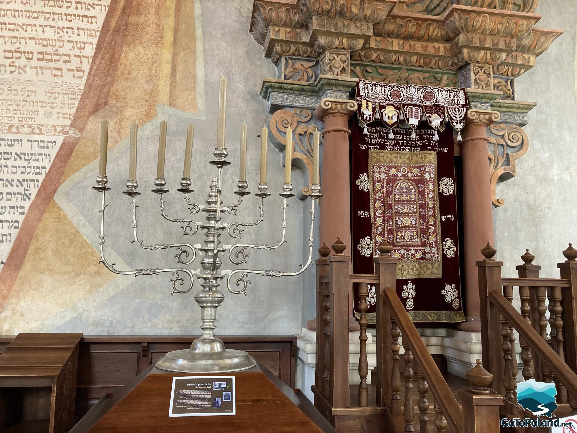 aron ha-kodesh in the synagogue, and in the foreground a Hanukkah candlestick with 9 cream candles