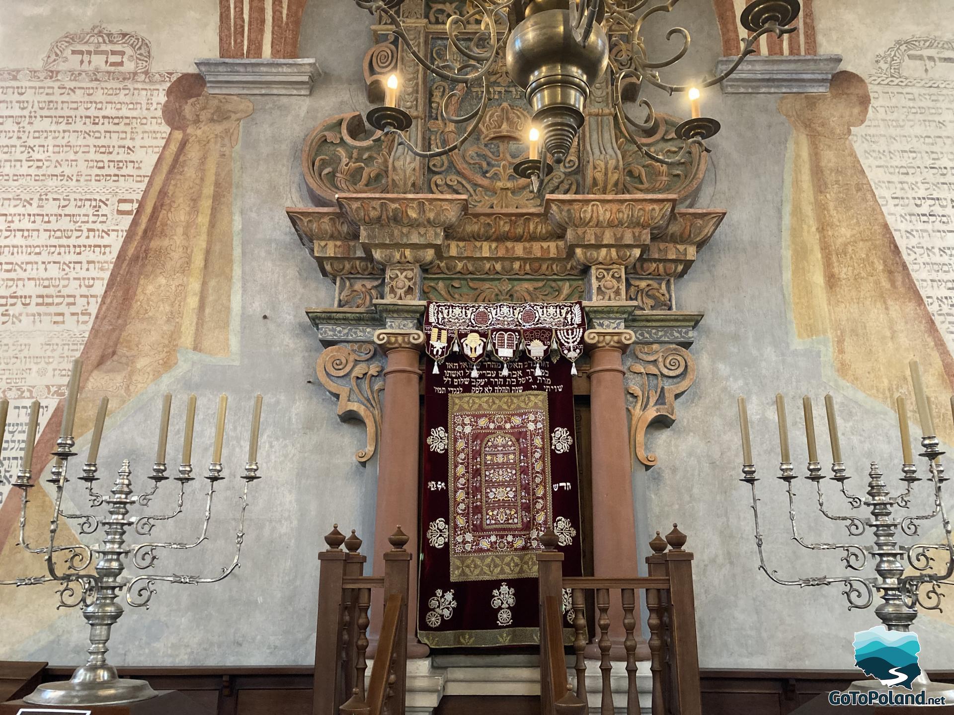 another view of aron ha-kodesh in the synagogue, and in the foreground two Hanukkah candlesticks with 9 cream candles
