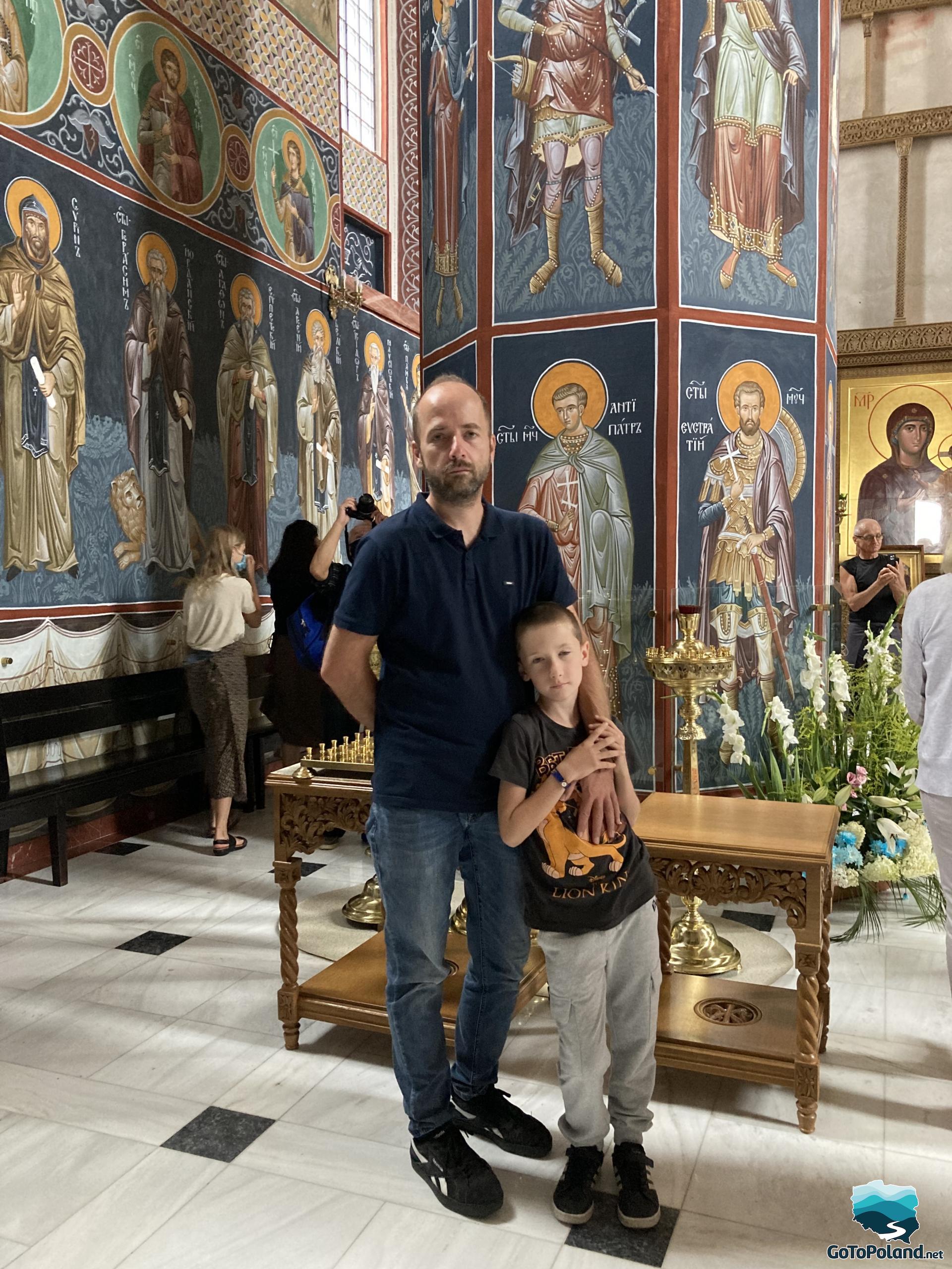 a man and a boy in the orthodox church highly decorated