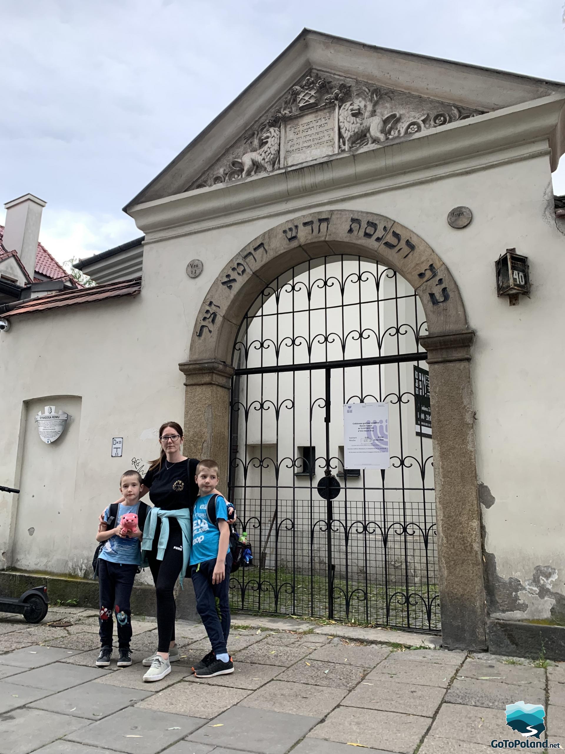 a woman and two children are in front of a synagogue 