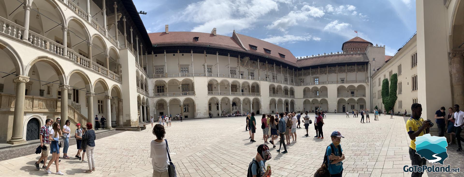 there are a lot of tourists in the courtyard of the castle