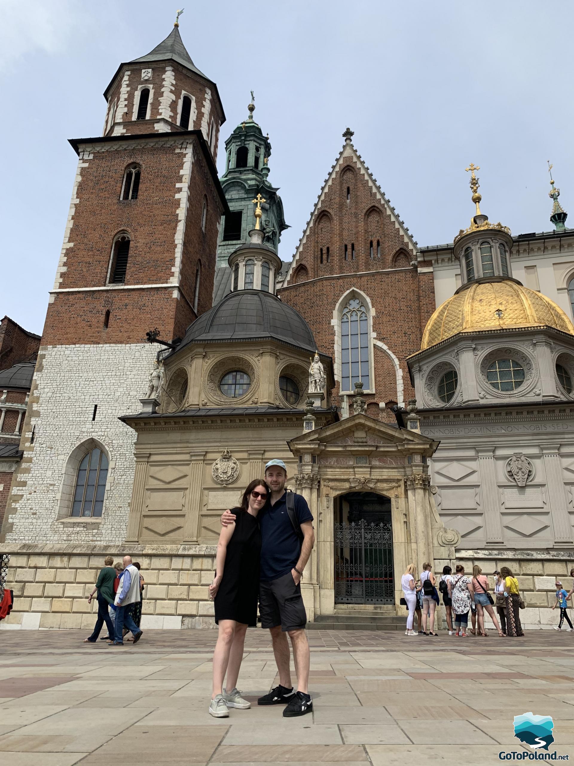 A couple is standing in front of the cathedral complex