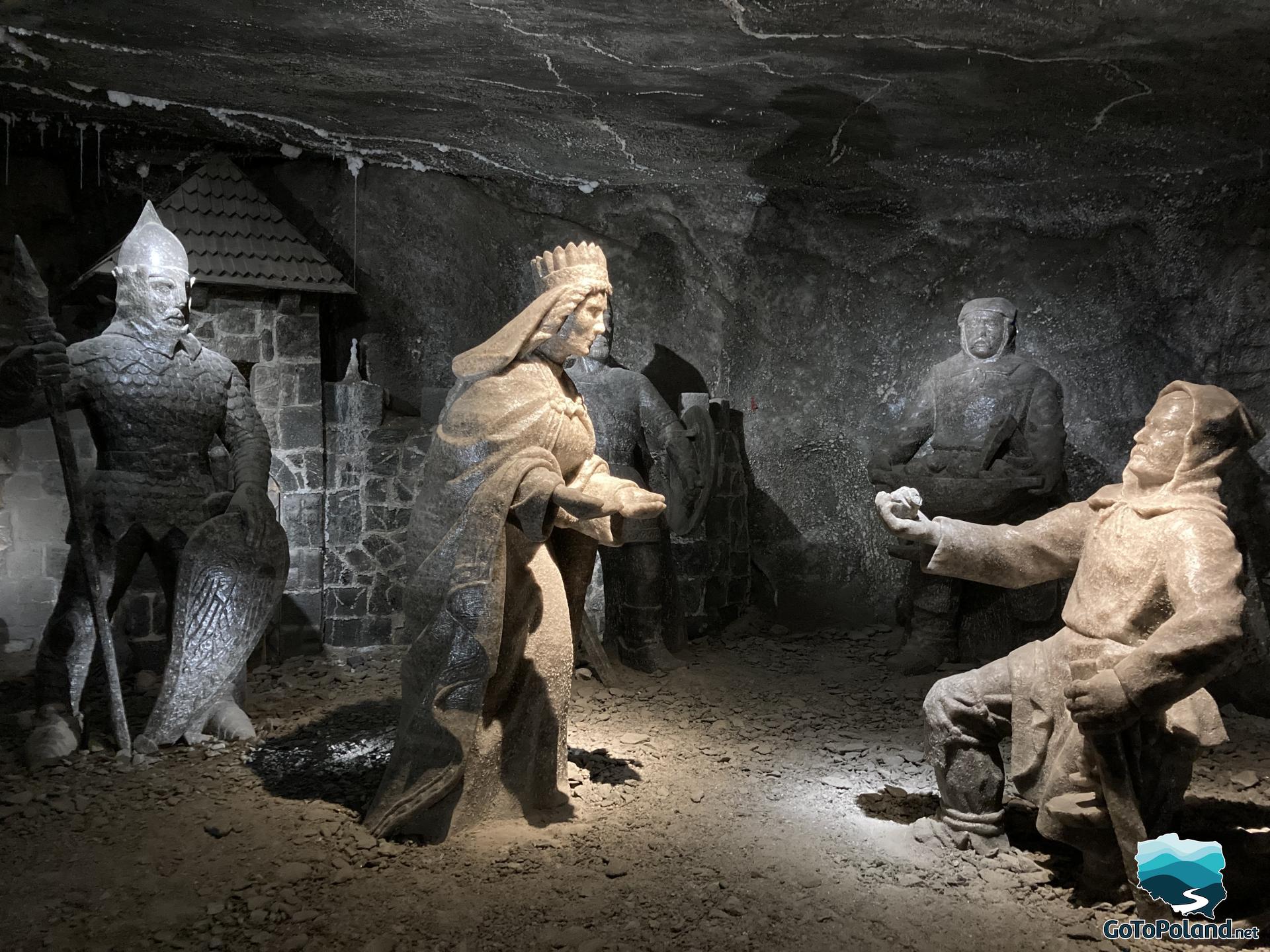 a scene presenting five figures carved in salt, two knights, two peasants and Kinga, the patron saint of miners. One peasant is kneeling and giving to her a small amount of salt 