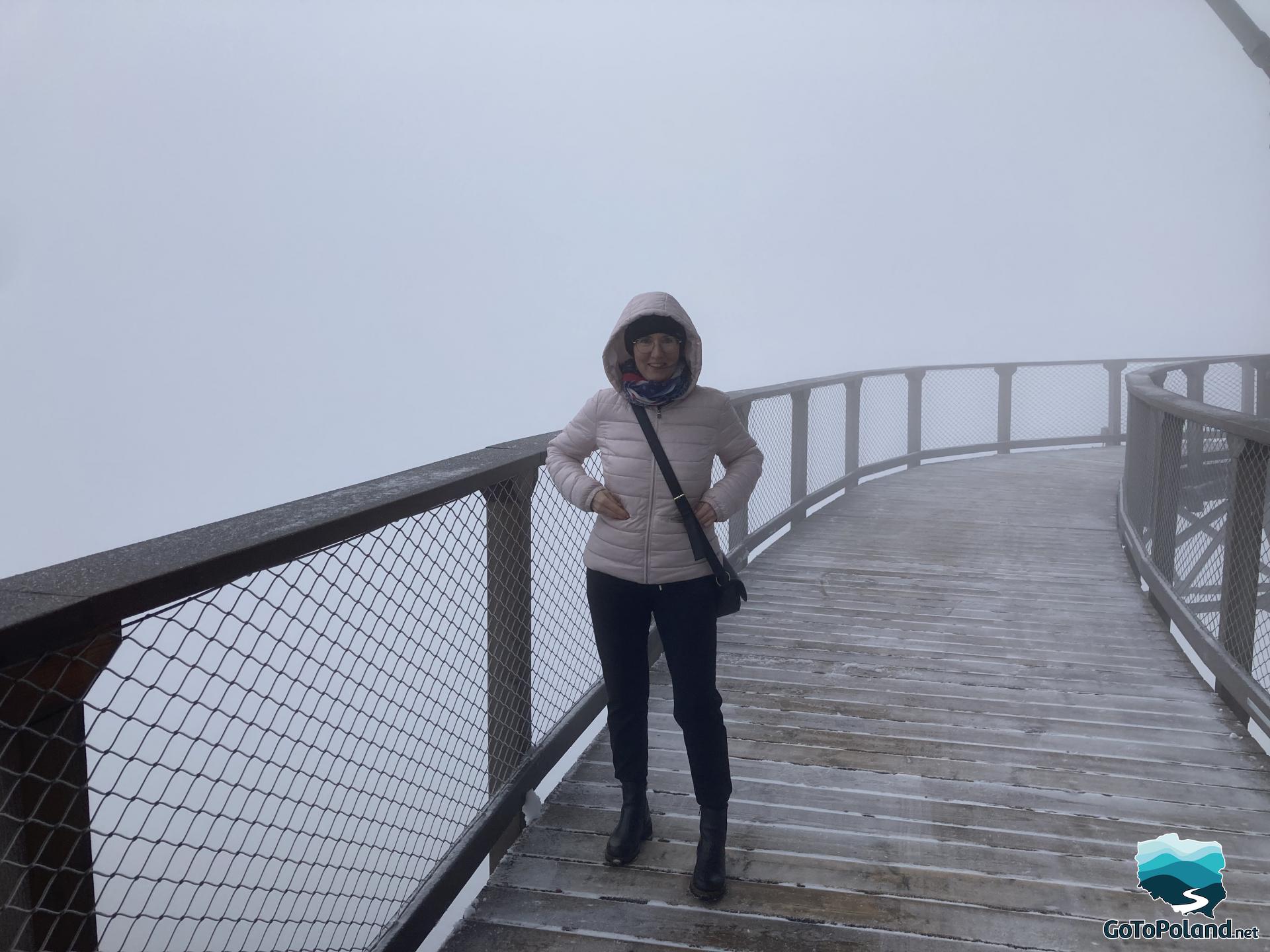 a woman is on a wooden path on an observation tower