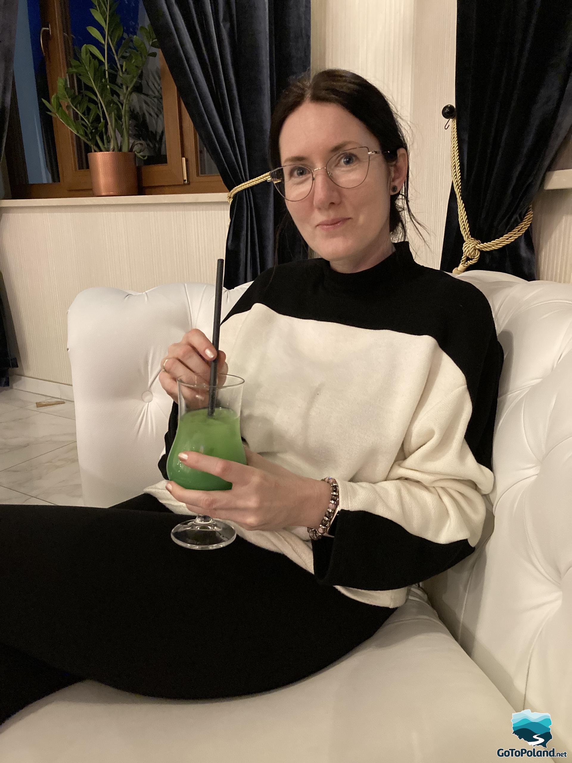 a woman is drinking a green drink