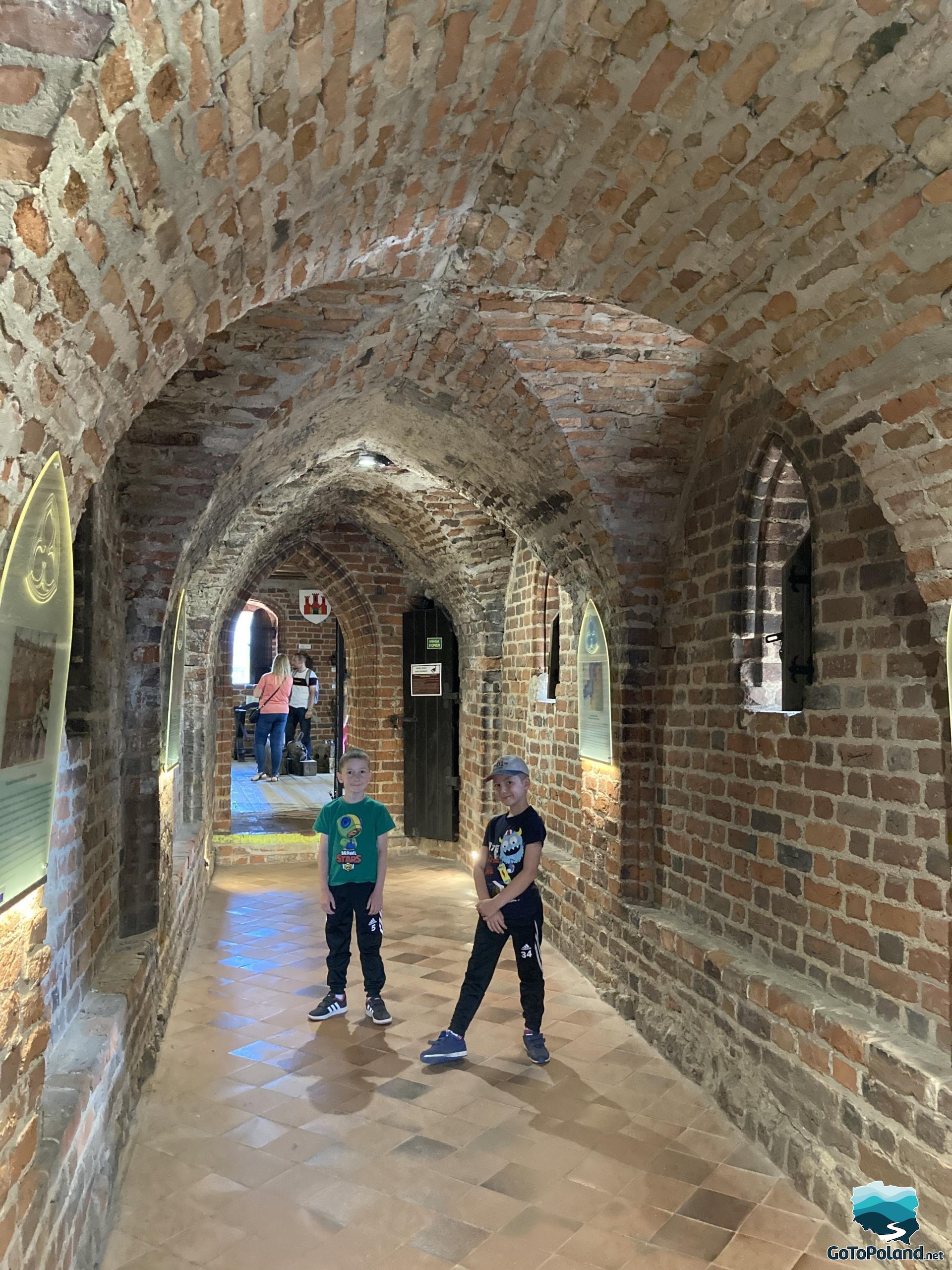 two children are standing in the corridor in the former castle