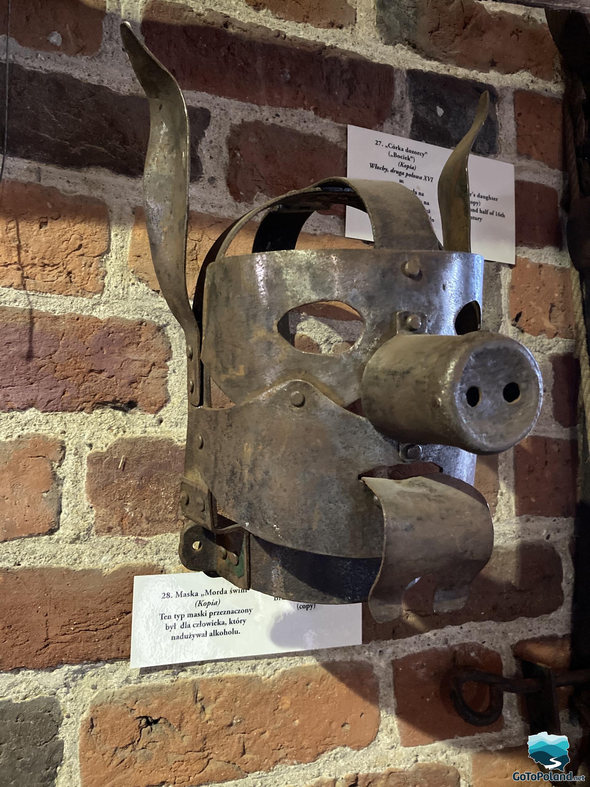 an old instrument of torture (some kind of a mask) hangs on the wall