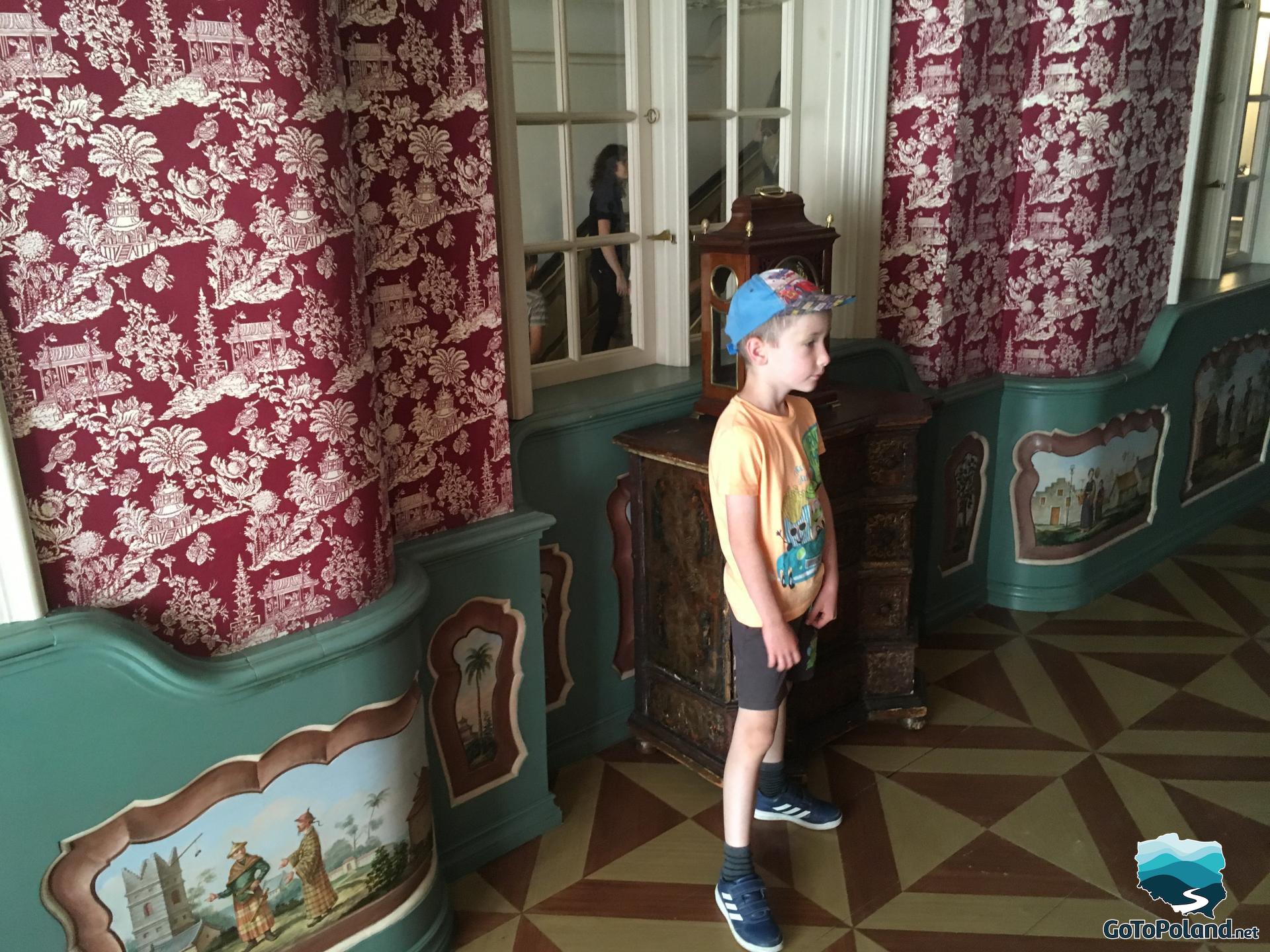 a boy is standing in a room in a historic tenement house