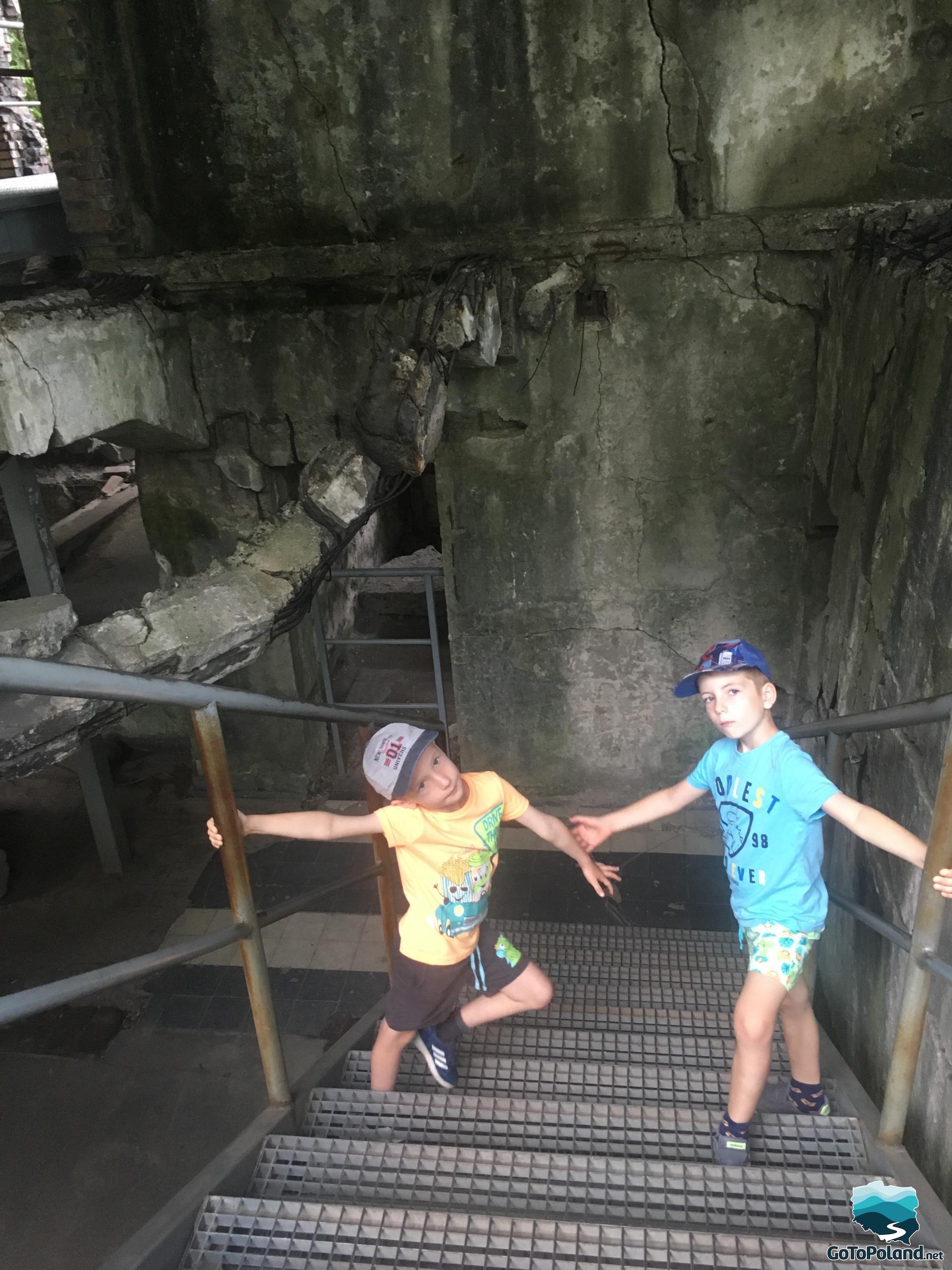 children are going down the stairs inside the ruins of the barracks