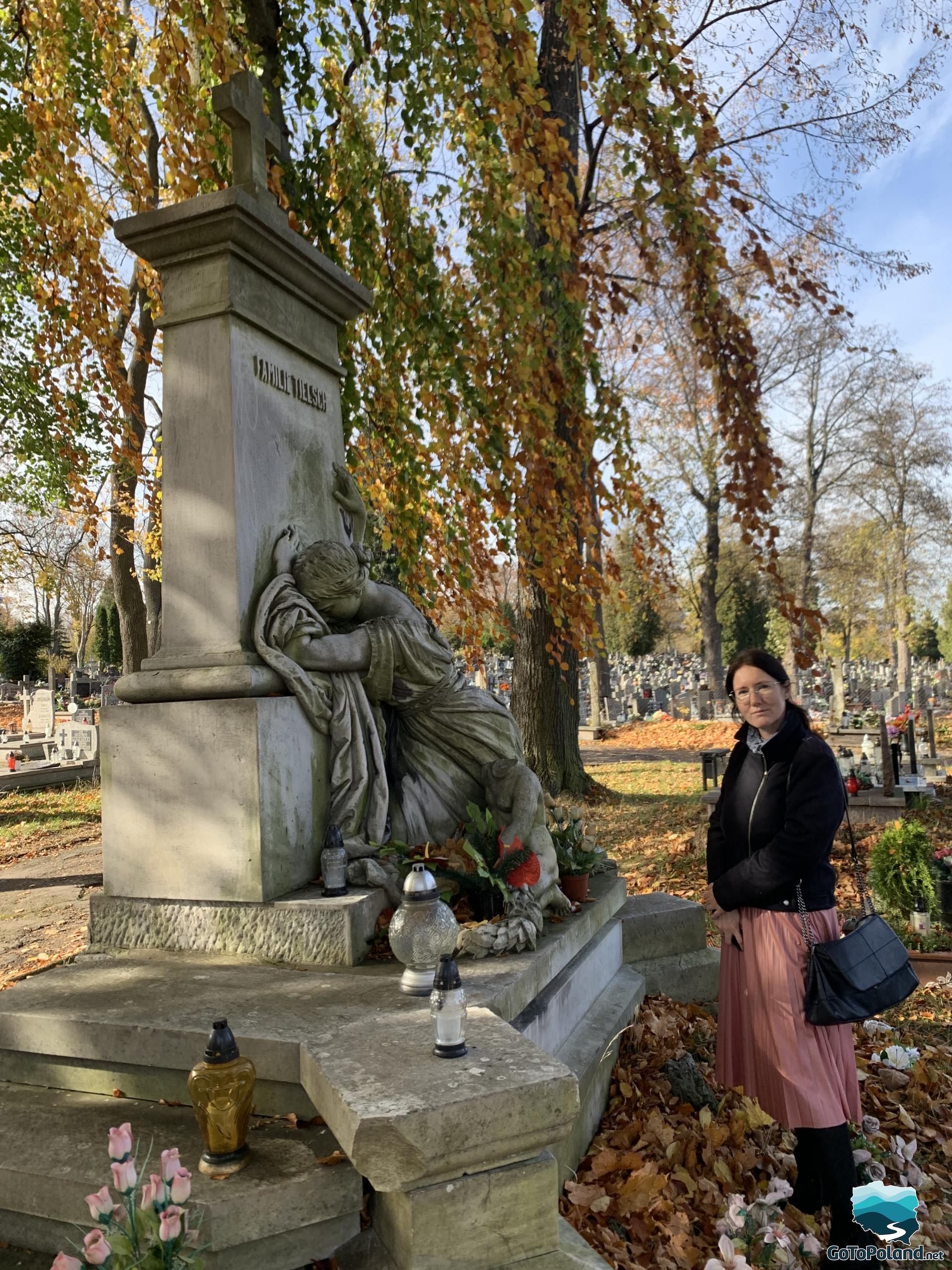 a woman is standing by the tombstone of Tielsch Family