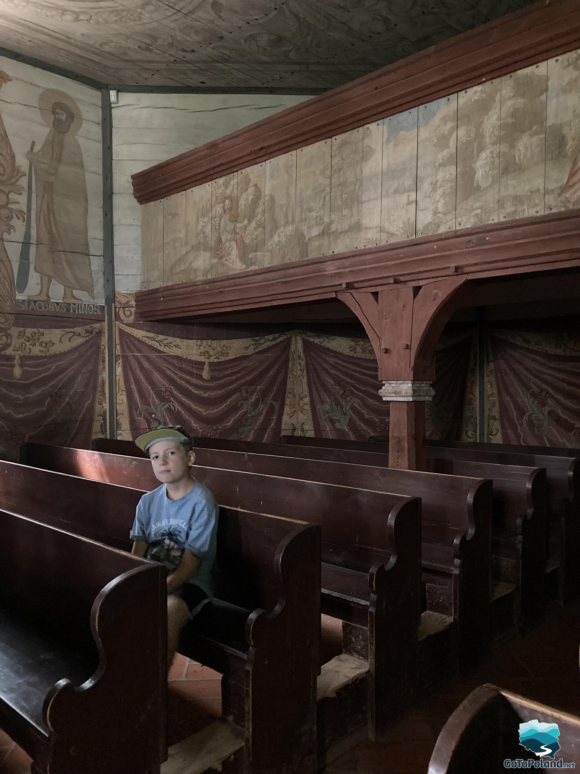 a boy in sitting inside the old wooden church