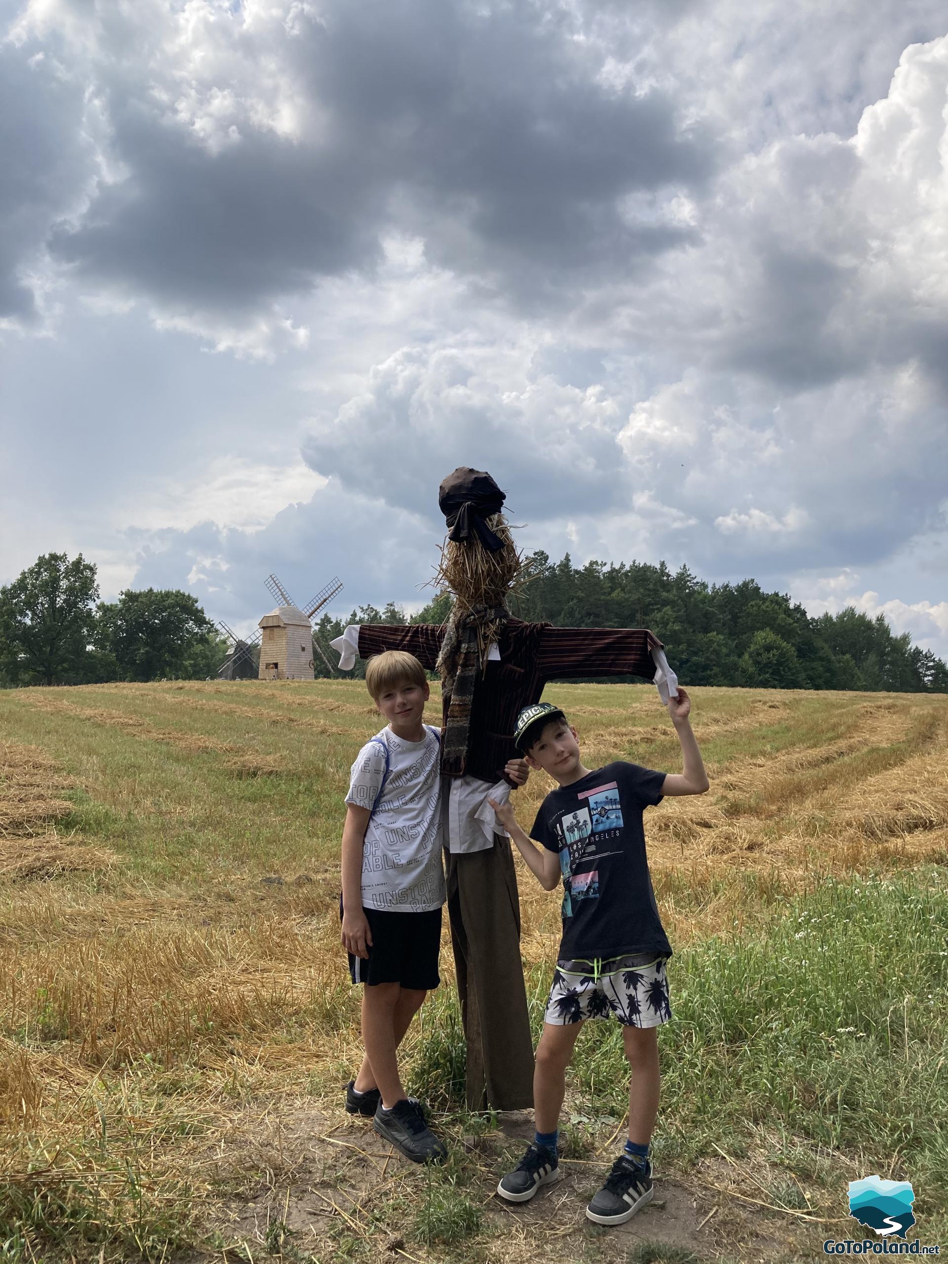 two boys standing by the scarecrow